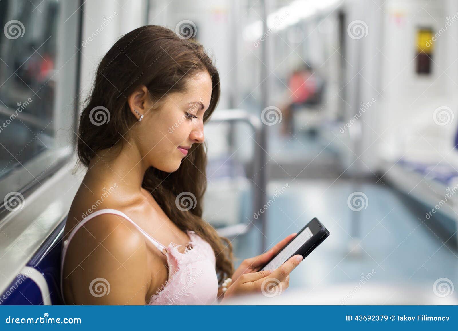 woman with ereader in subway train