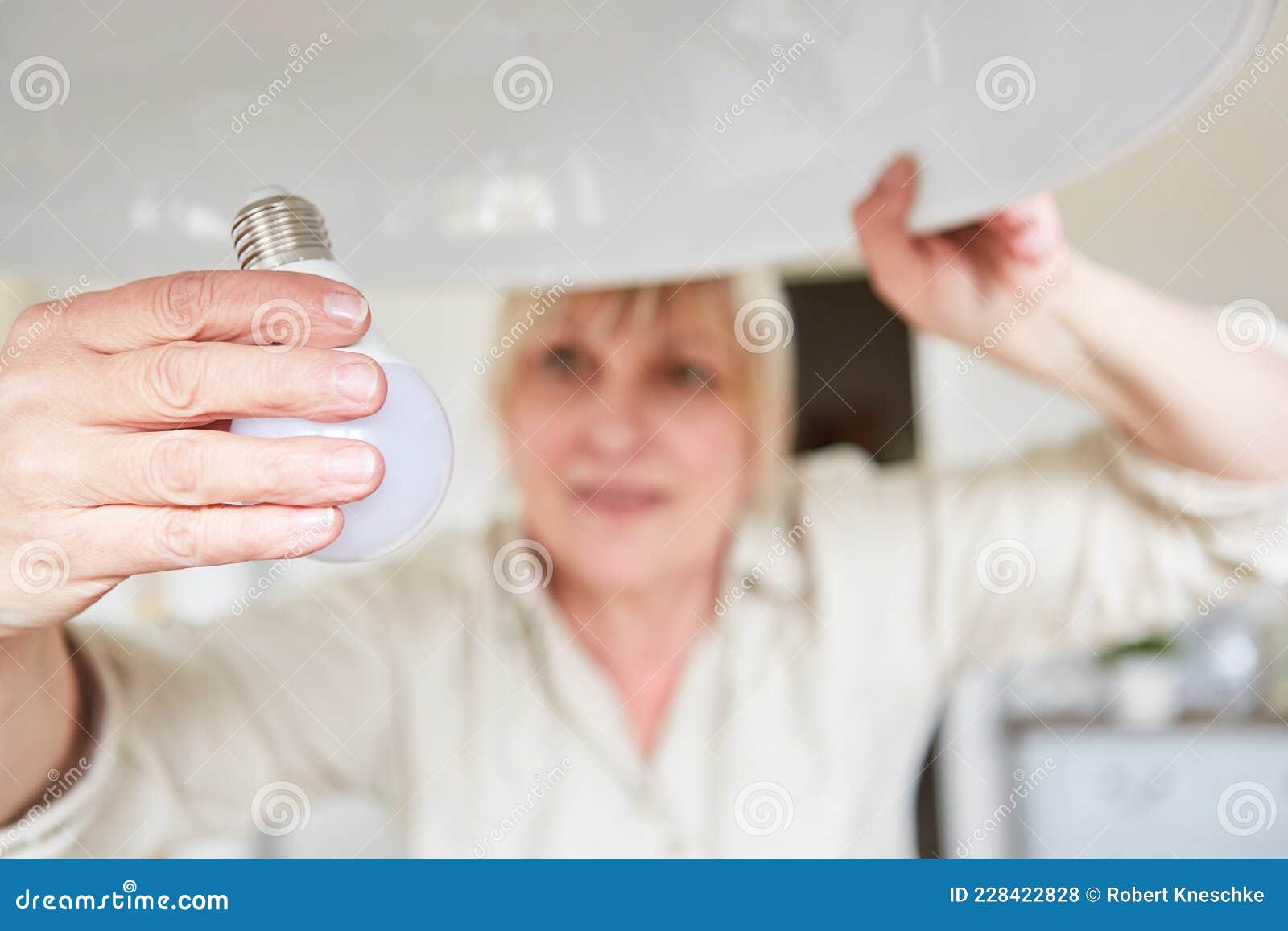 Woman Exchanges Lightbulb for Energysaving Lamp Stock Photo Image of