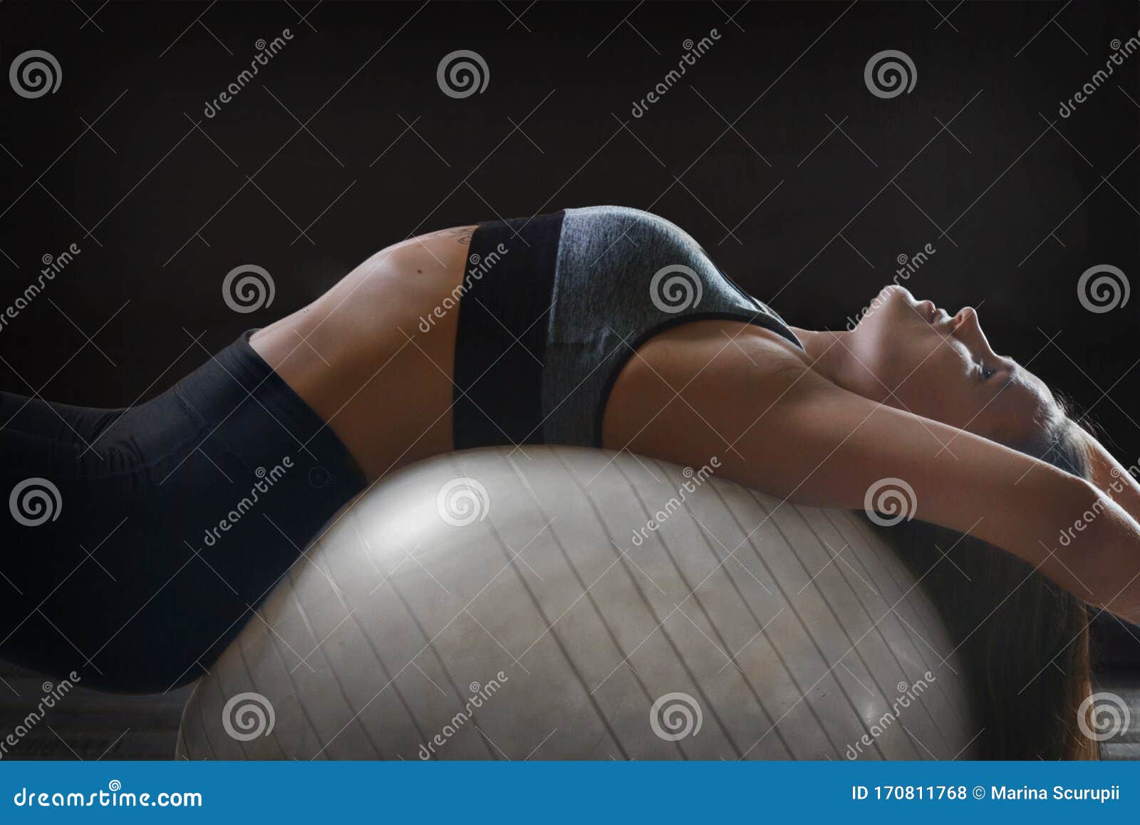 woman exercising her abs on a pilates fit ball