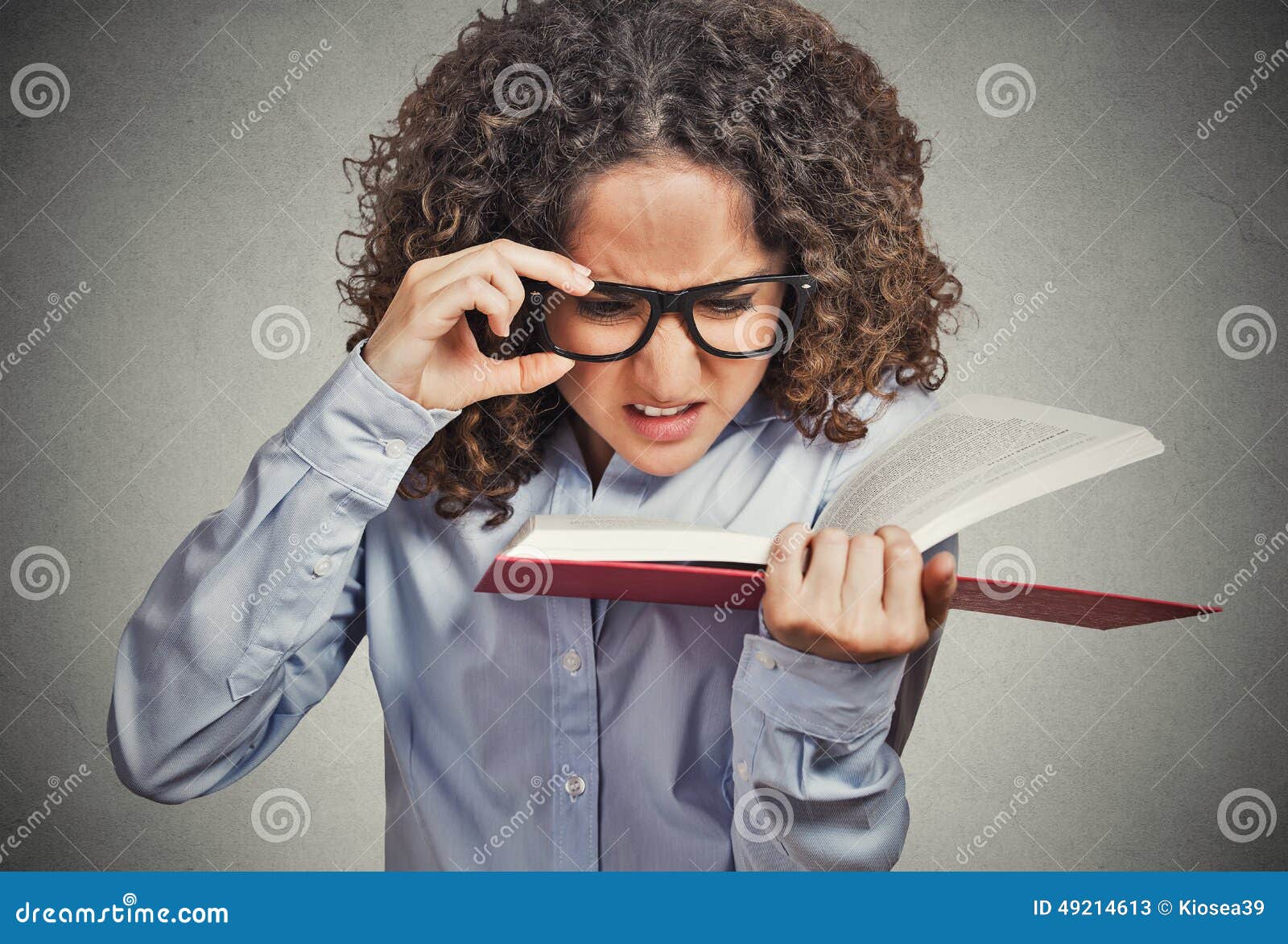 woman with eye glasses trying to read book, having difficulties seeing text