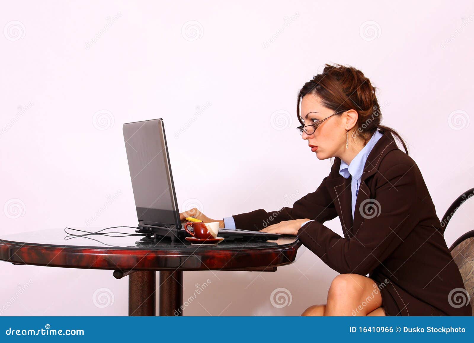woman with eyeglasses working on lap top computer