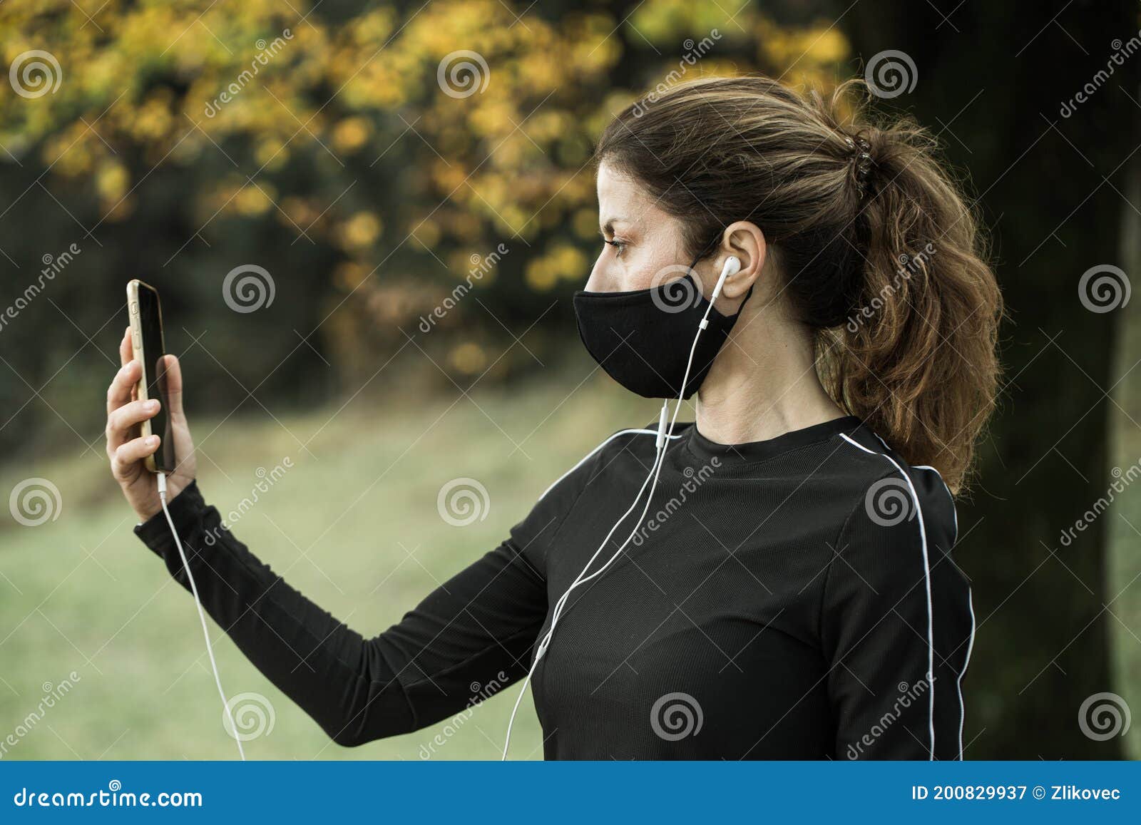 woman with face mask taking video call. giving lectures while working out during covid-19