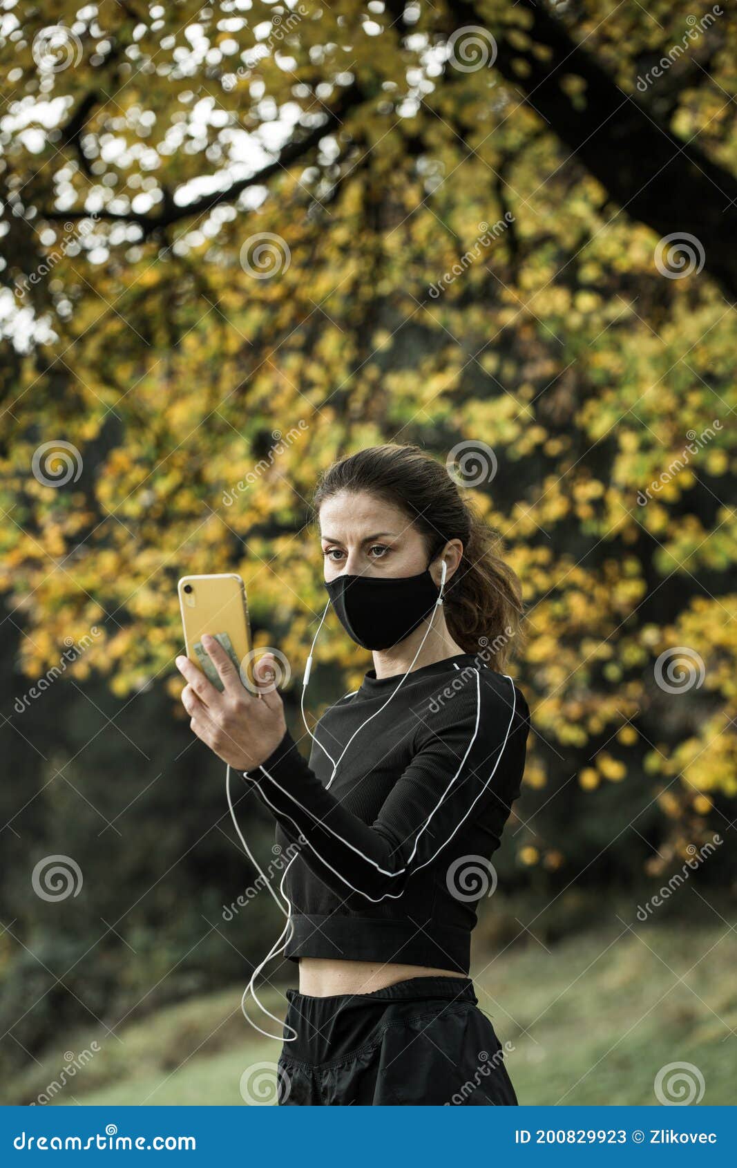 woman with face mask taking video call. giving lectures while working out during covid-19