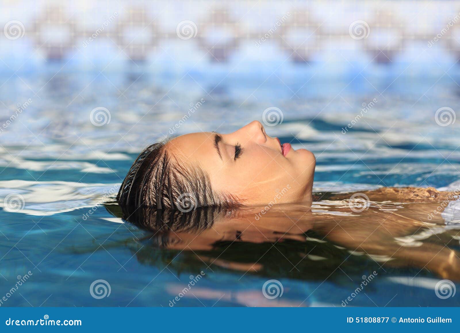 woman face relaxing floating on water of a pool or spa