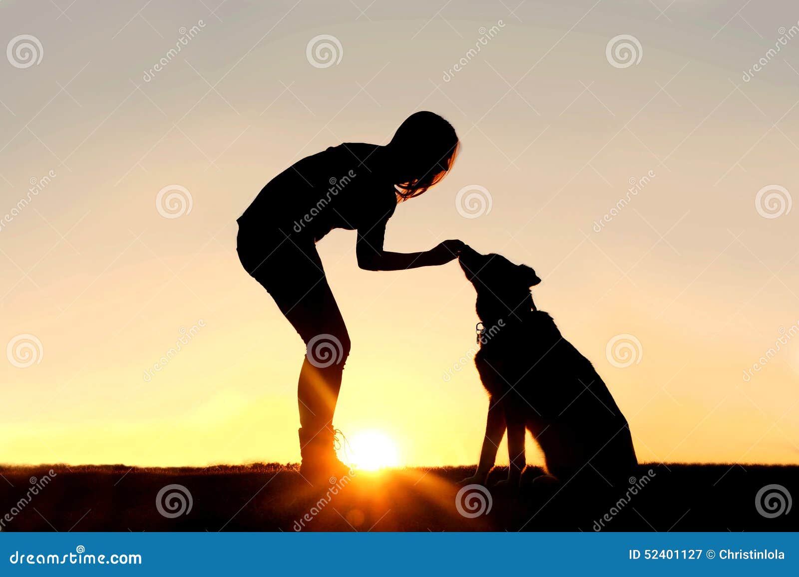 woman feeding pet dog treats silhouette
