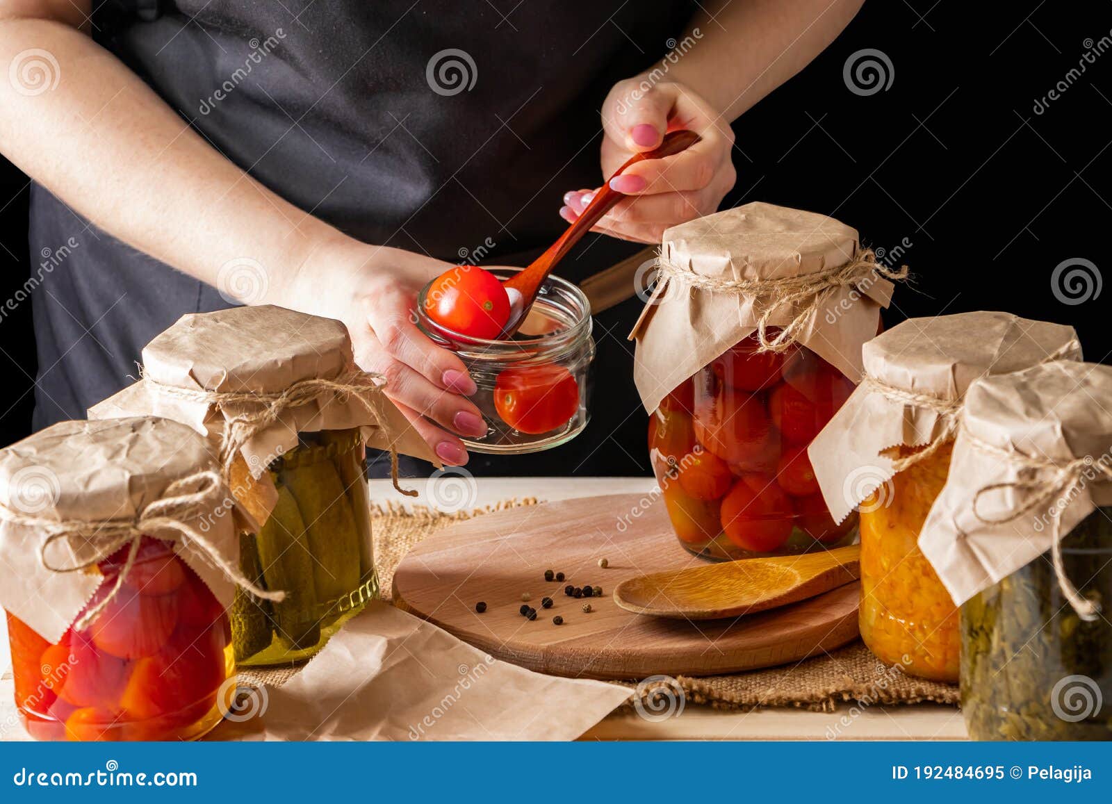 a woman ferments vegetables. pickled tomatoes in jars. preserving the autumn harvest. organic food