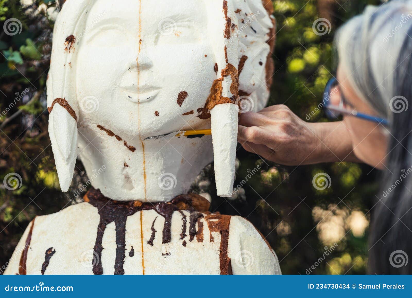 woman filing a piece of polystyrene with a spatula outdoors