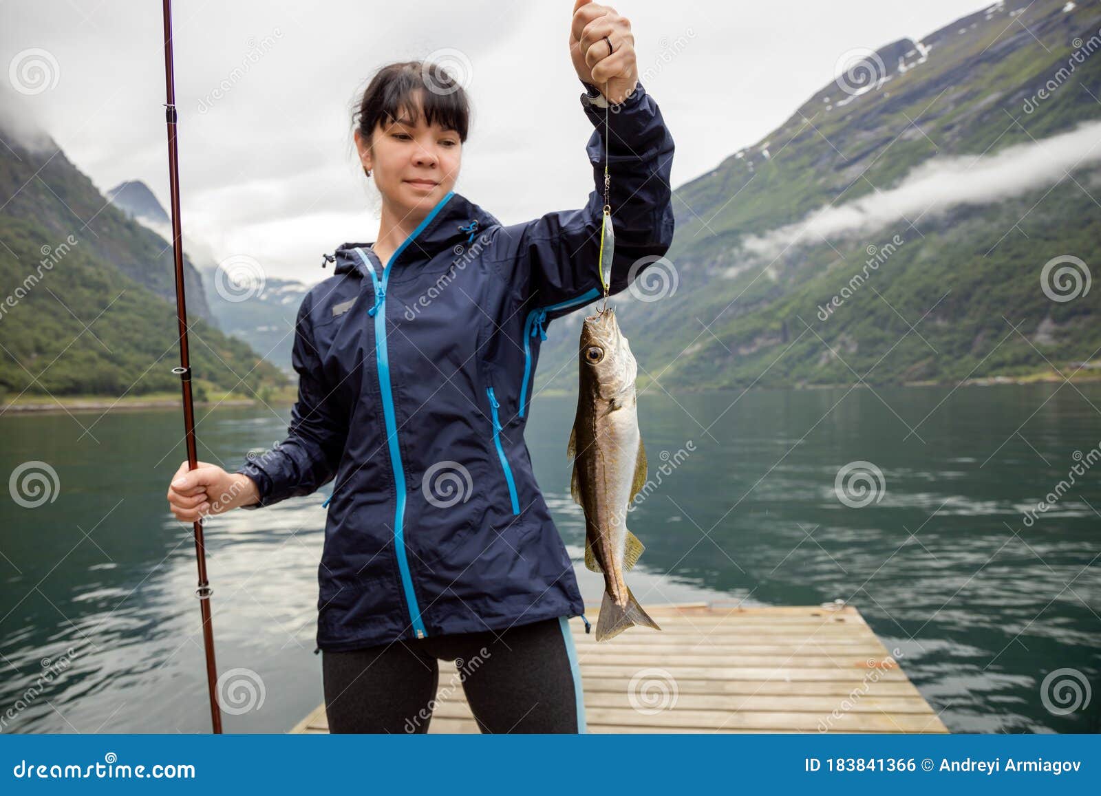 Woman Fishing on Fishing Rod Spinning in Norway Stock Photo