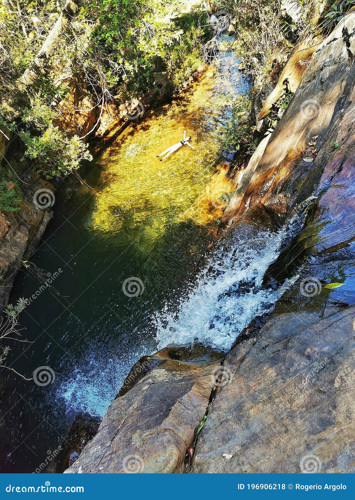 woman floating in water at waterfall cruzados at acuruÃÂ­, minas gerais, brazil