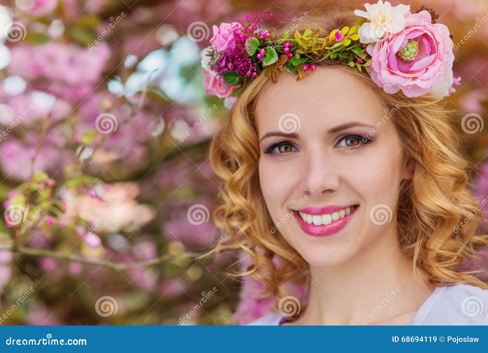woman with flower wreath against pink tree in blossoom