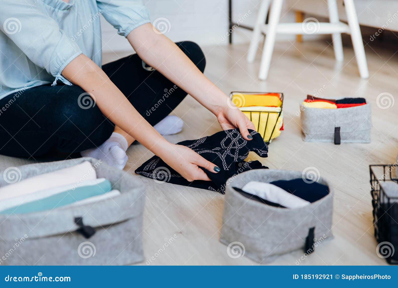 woman folding clothes on the floor, organizing stuff and laundry
