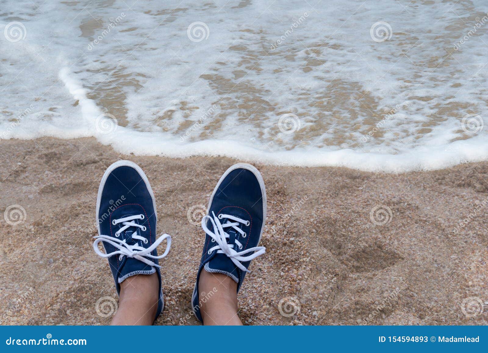 Woman Foot in Blue Casual Sneaker Shoes on the Beach with Sea Water ...