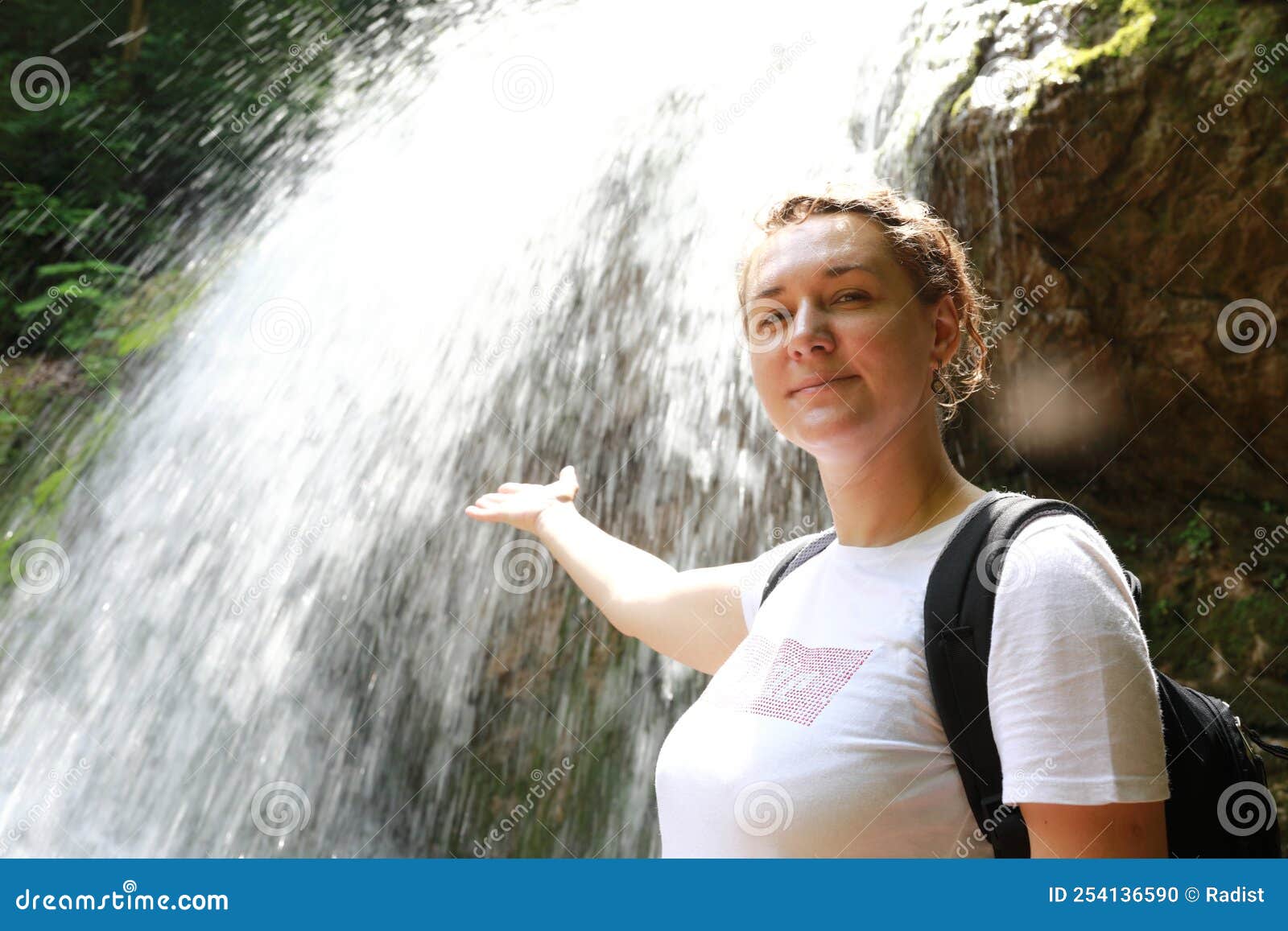 woman in front of waterfall shum on rufabgo stream in summer