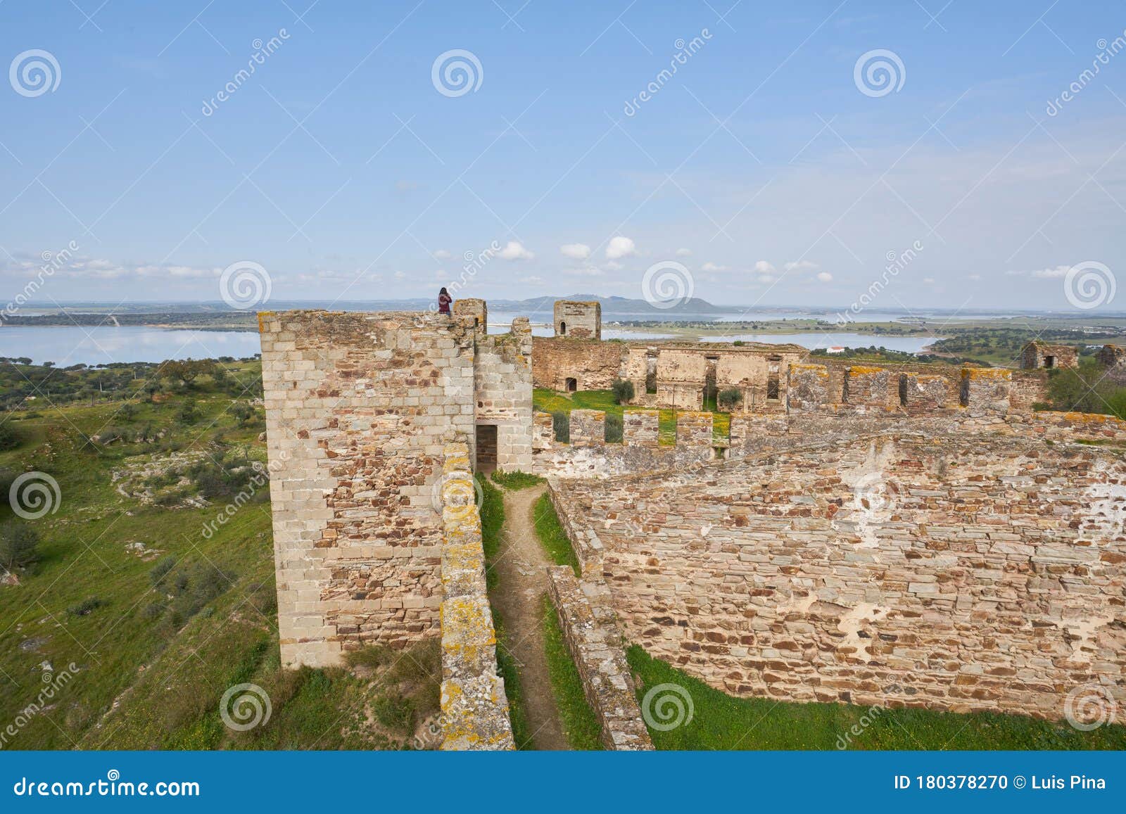 woman girl traveler in mourao castle towers and wall historic building in alentejo, portugal