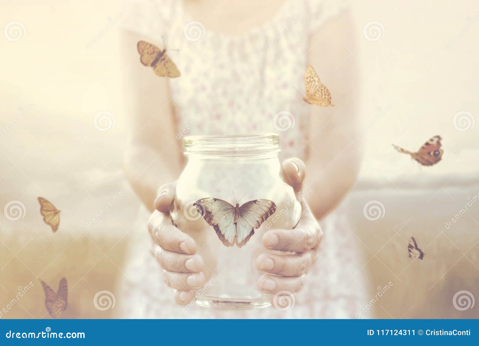 woman gives freedom to some butterflies enclosed in a glass vase