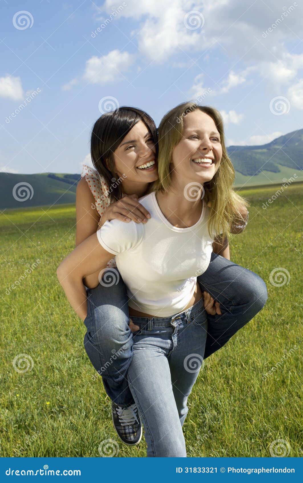 Girl giving her friend a piggyback ride stock photo