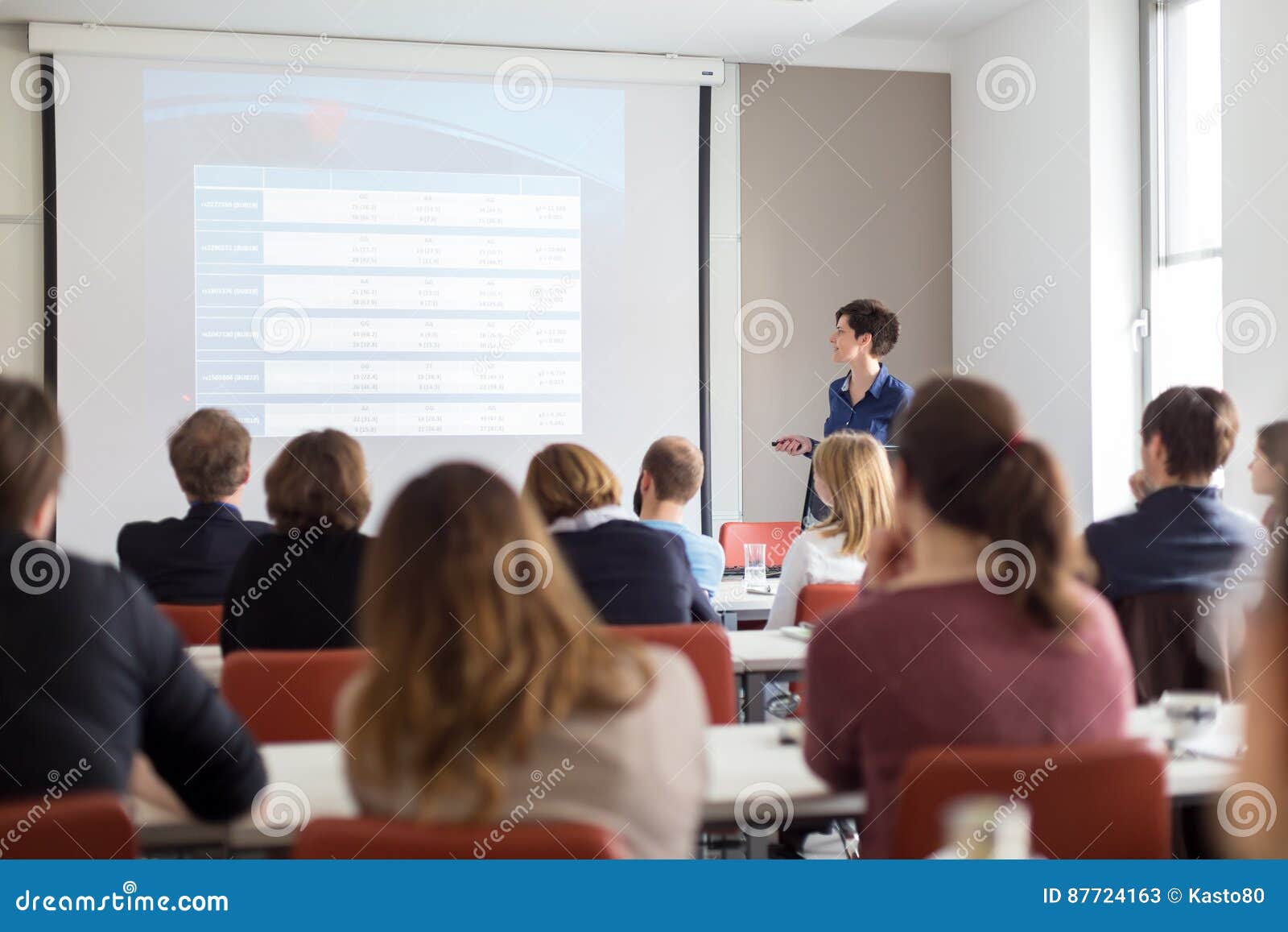 woman giving presentation in lecture hall at university.