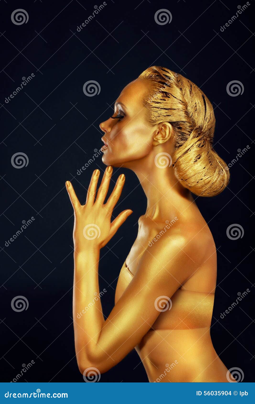 Body Art. Woman painting Body with Paint Brush in Golden Color