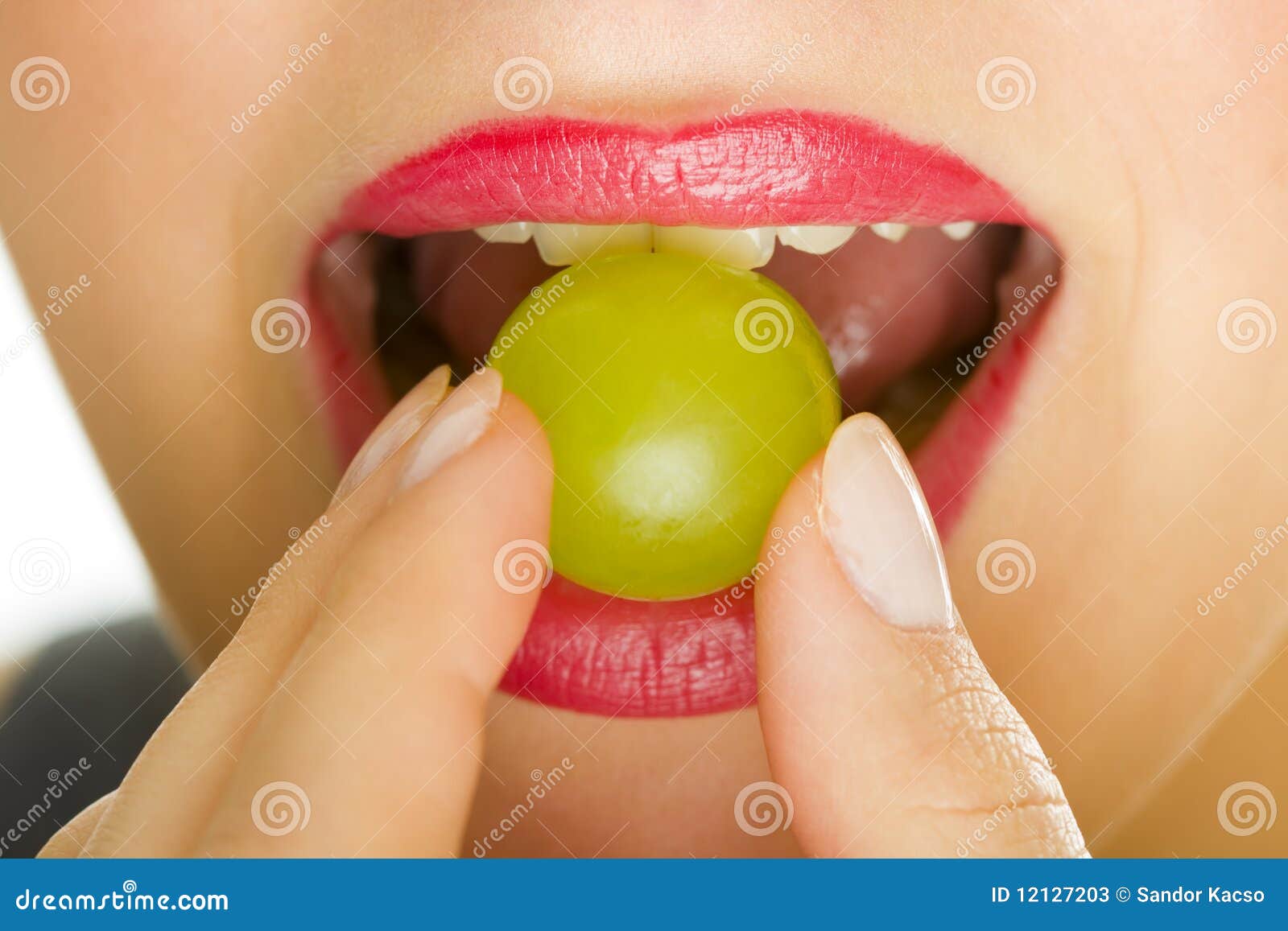 Woman with grape in mouth stock image. Image of lipstick 12127203