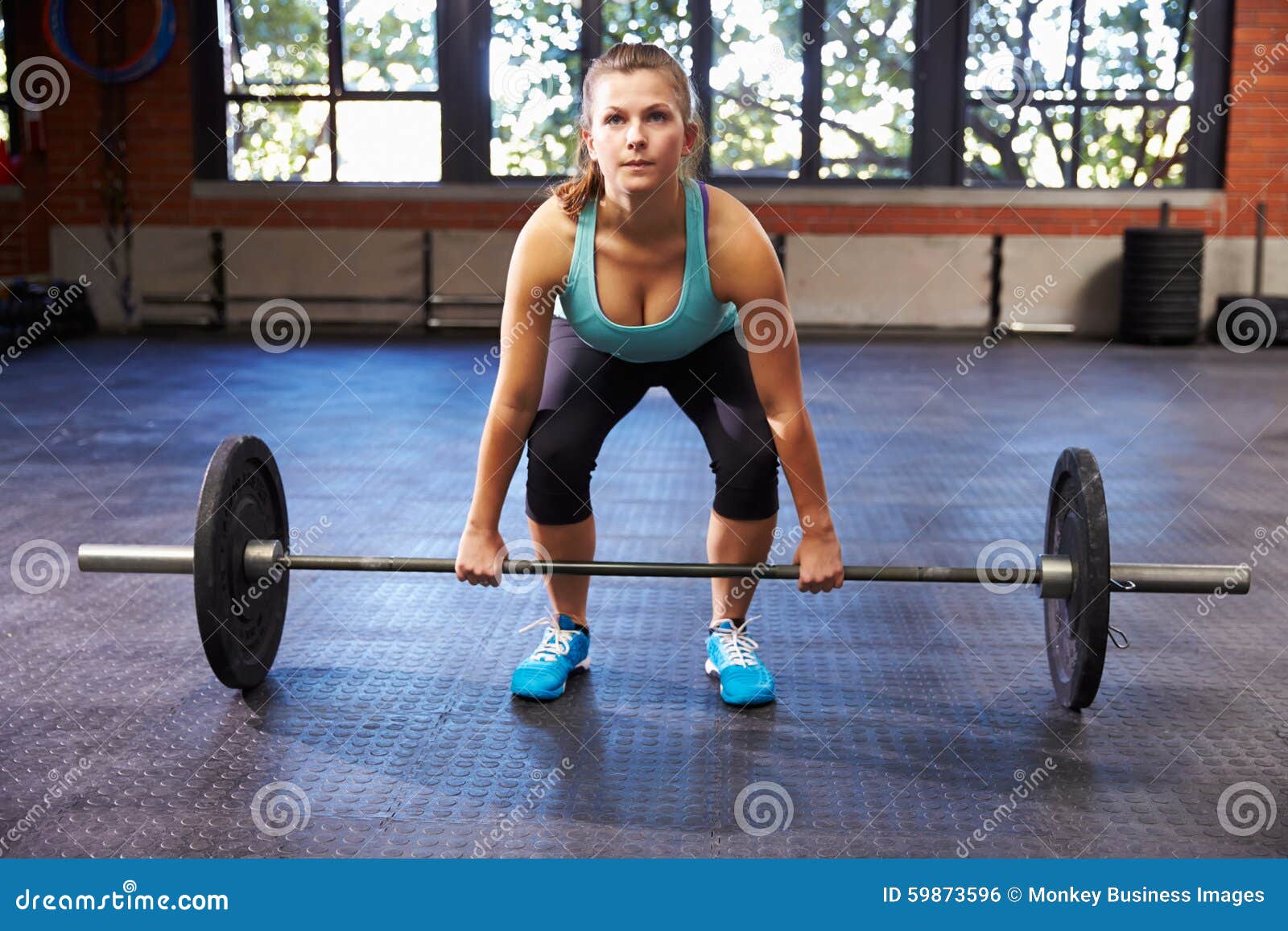 Woman In Gym Preparing To Lift Weights