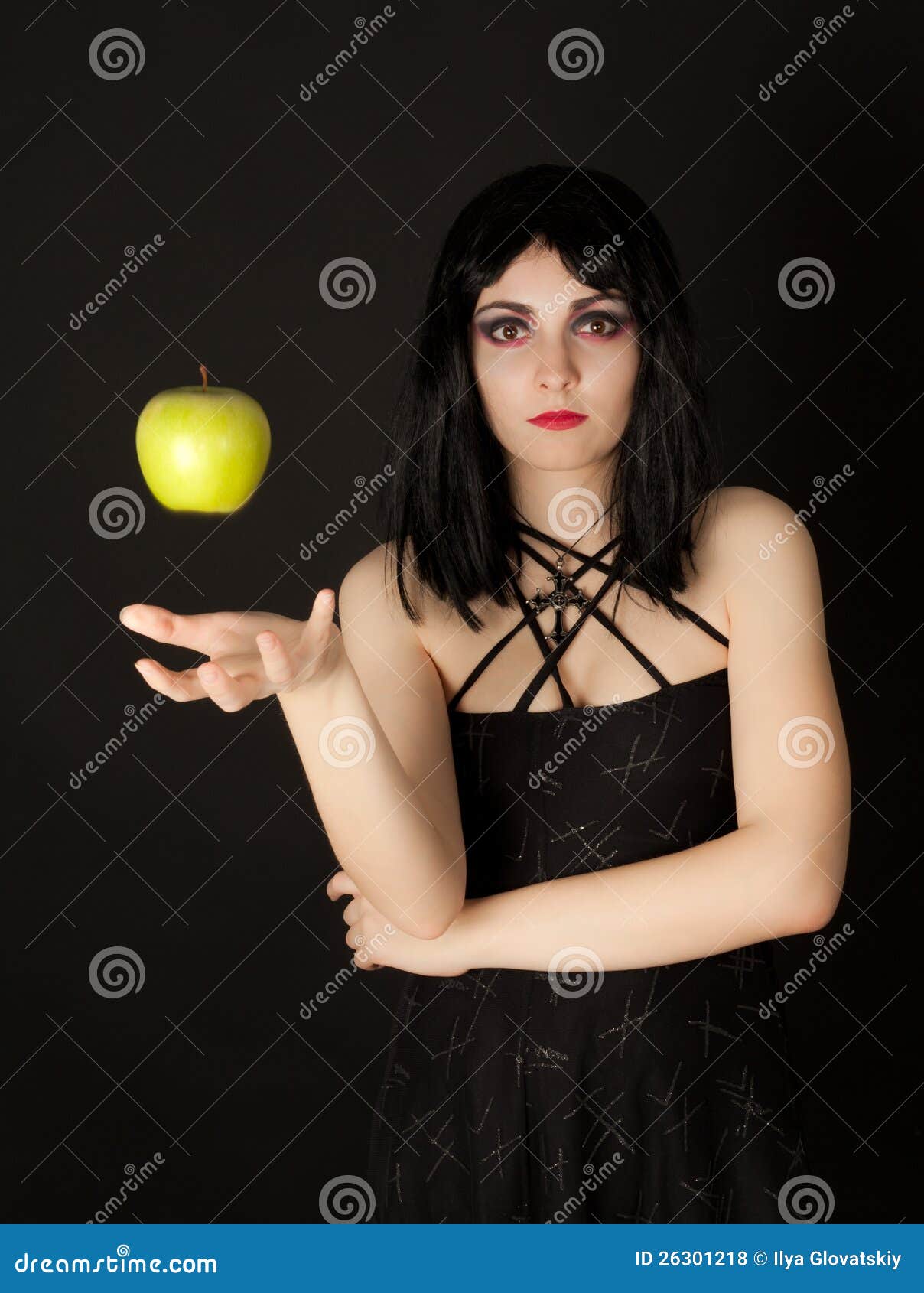 woman with halloween make up sthrowing green apple