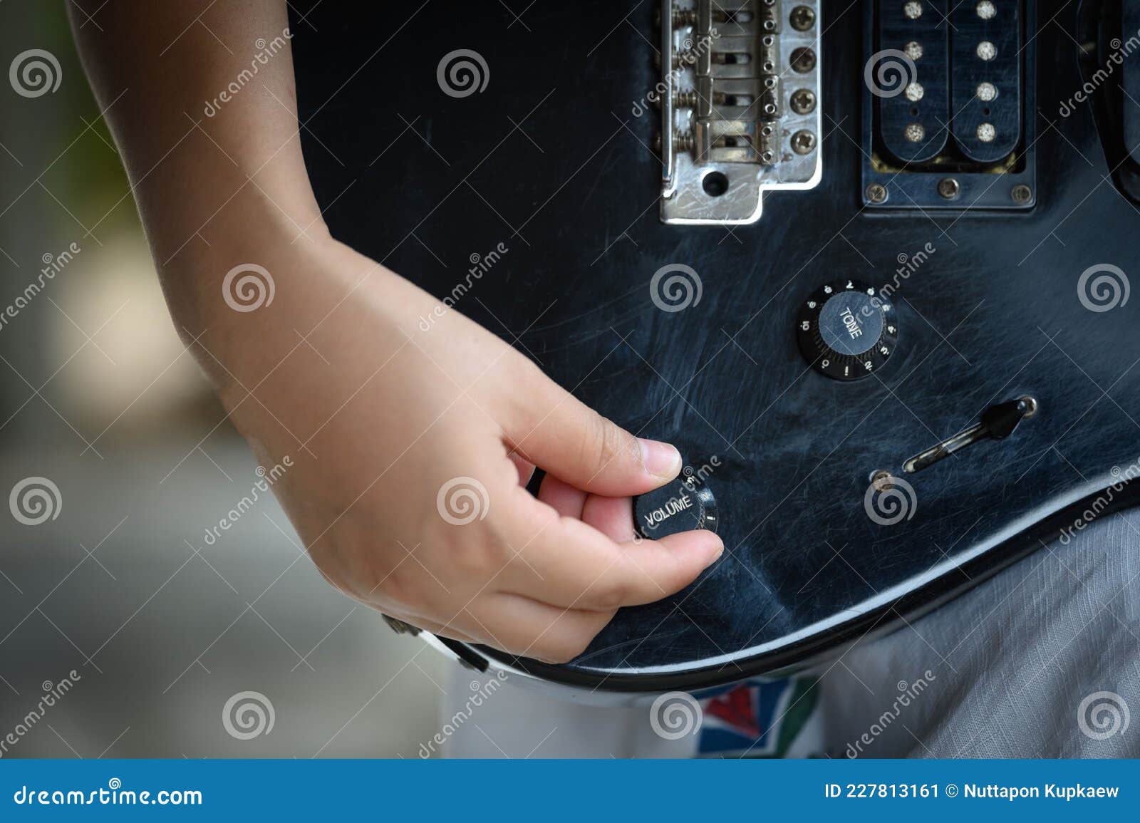 woman hand changing electric guitar settings. tuning a timbre regulator