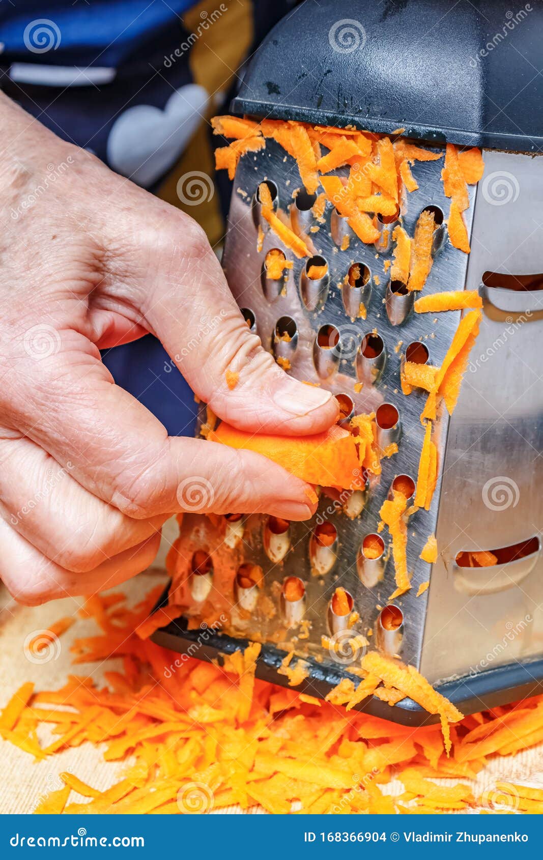 Woman Hand Grating Fresh Bright Orange Carrot on the Stainless Steel ...