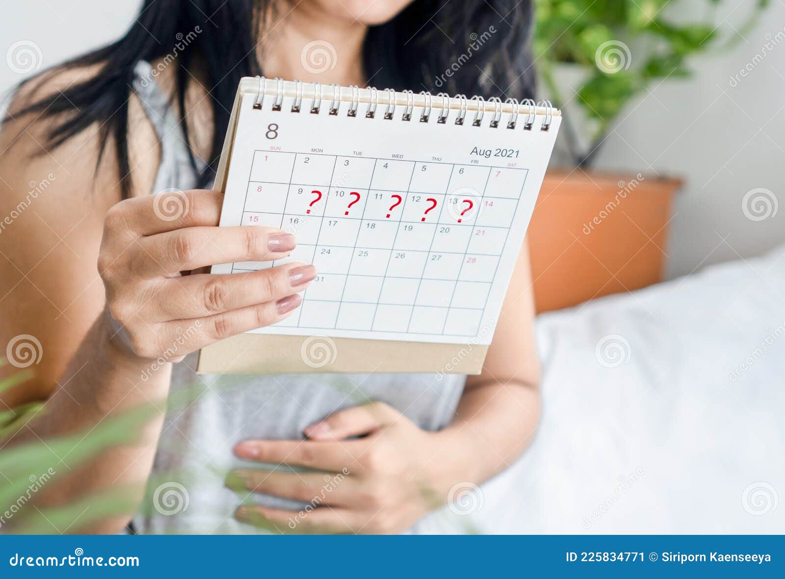 woman hand holding calendar with question mark waiting for late blood period, amenorrhea, irregular periods concept