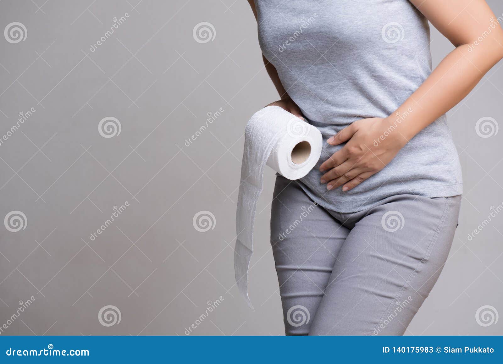 woman hand holding her crotch lower abdomen and tissue or toilet paper roll. disorder, diarrhea, incontinence. healthcare concept