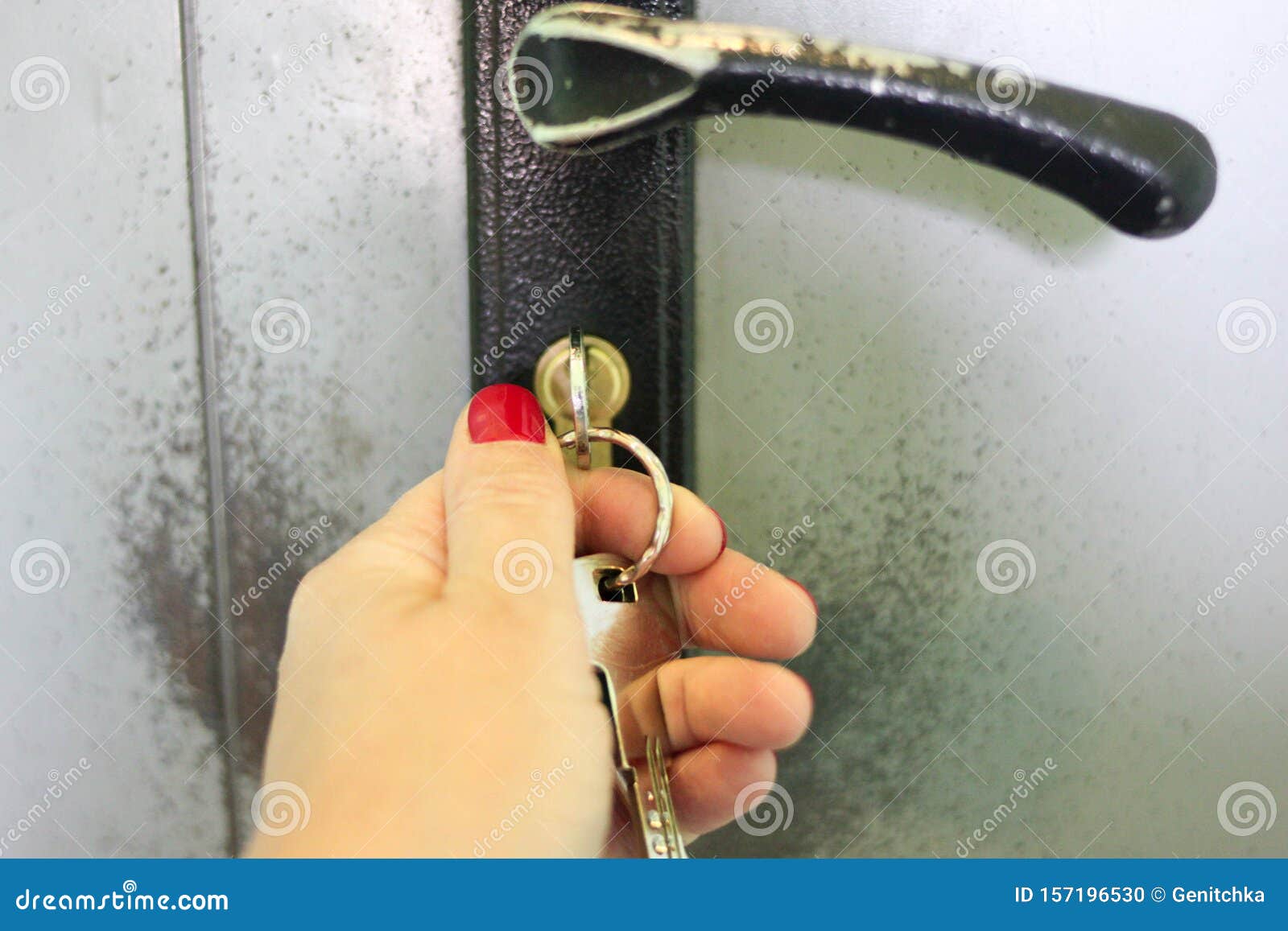 Woman Hand Locking Or Unlocking Door With Key On Bunch On Grey Old