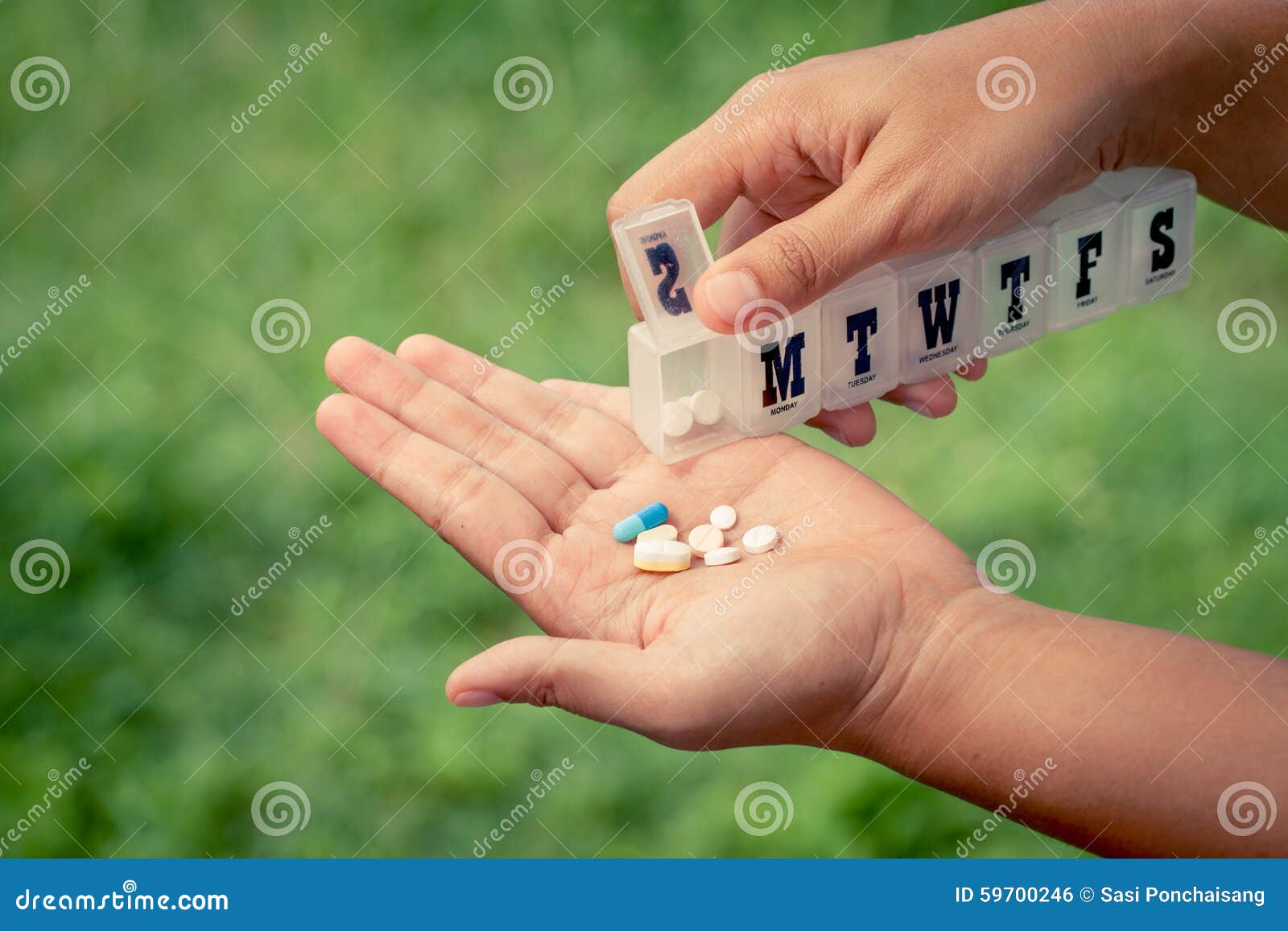 Woman Hand Pouring Pills From A Pill Reminder Box Into Her Hand Stock