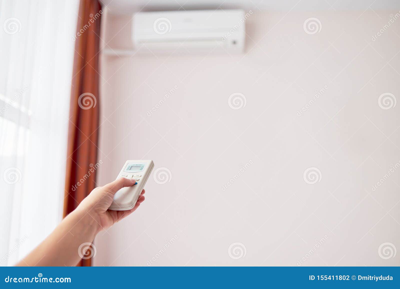 Woman Hand With Remote Control Operating Air Conditioner Inside