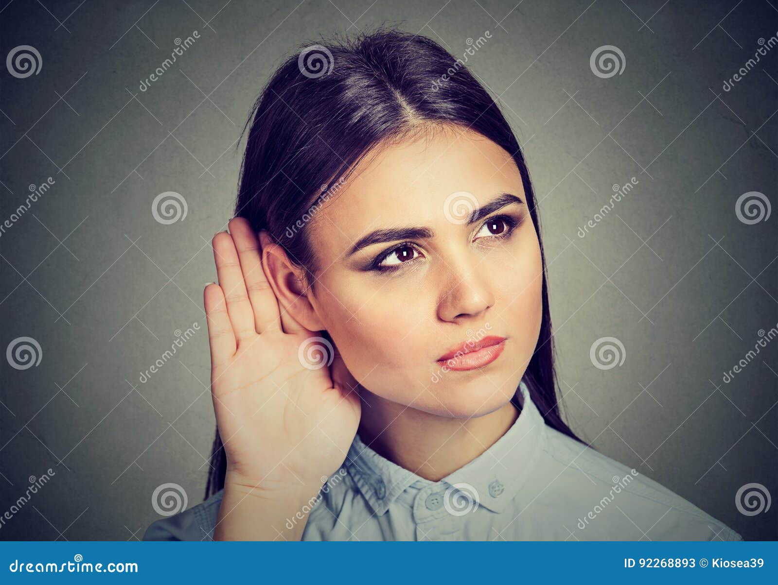 woman with hand to ear gesture listening carefully