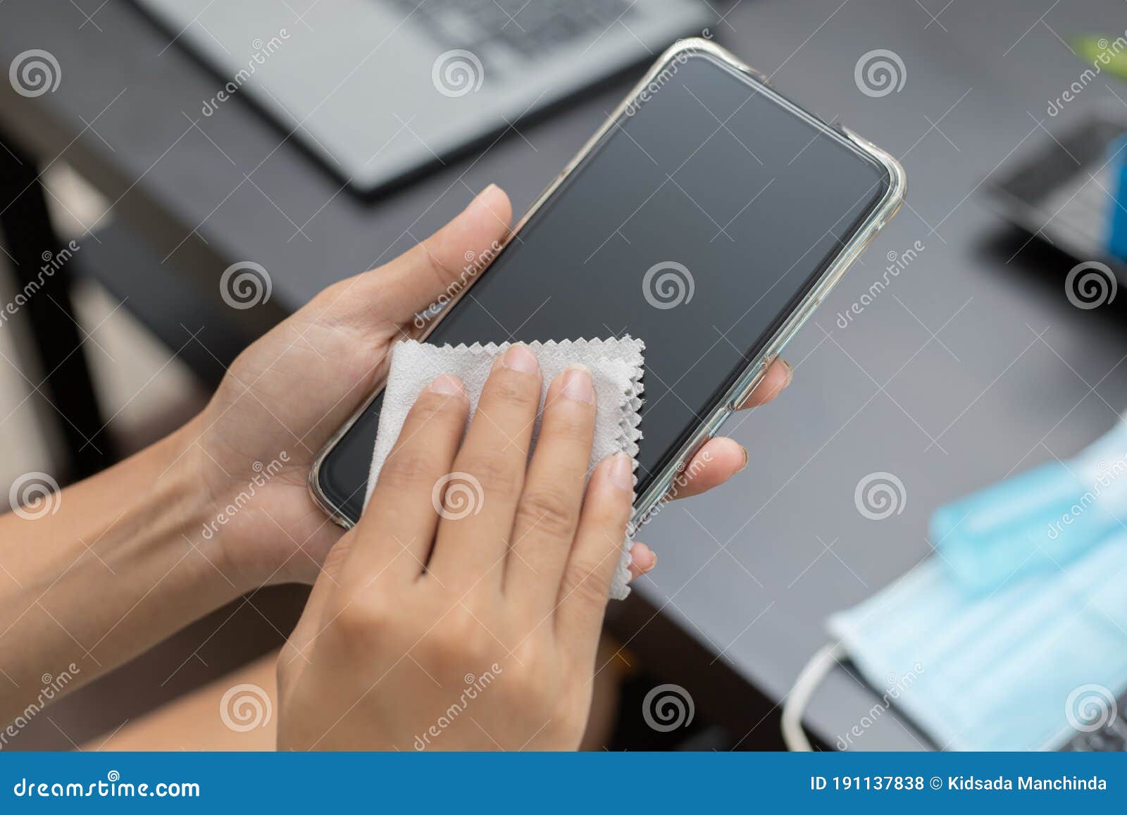 woman hand is wiped clean mobile phone with a cloth and alcohol to kill harmful virus, germs