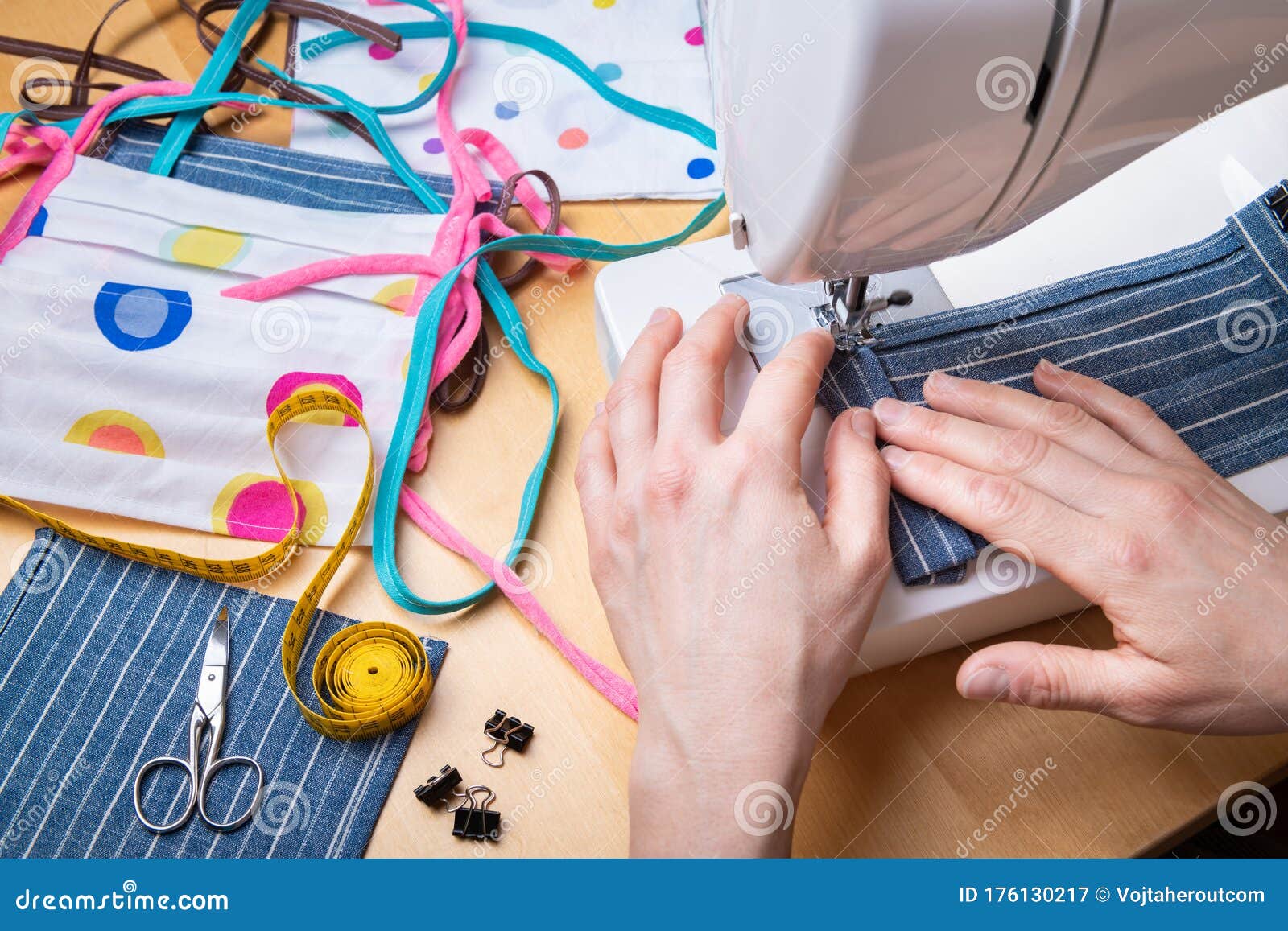 woman hands using the sewing machine to sew the face mask during the coronavirus pandemia. domestic sewing due to the shortage of