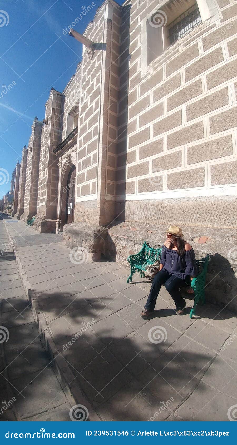 latin adult woman with hat and glasses tourist in the city of zacatecas mejico discovers and walks through the colonial streets