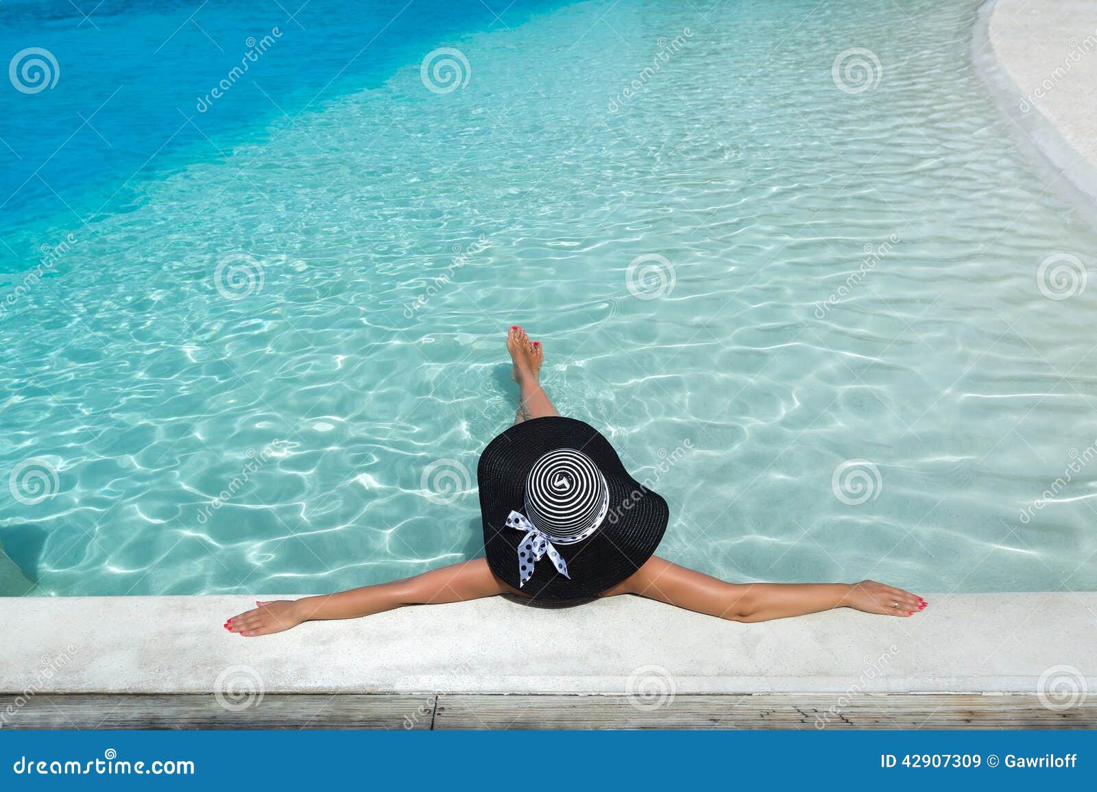 woman in hat relaxing at the pool