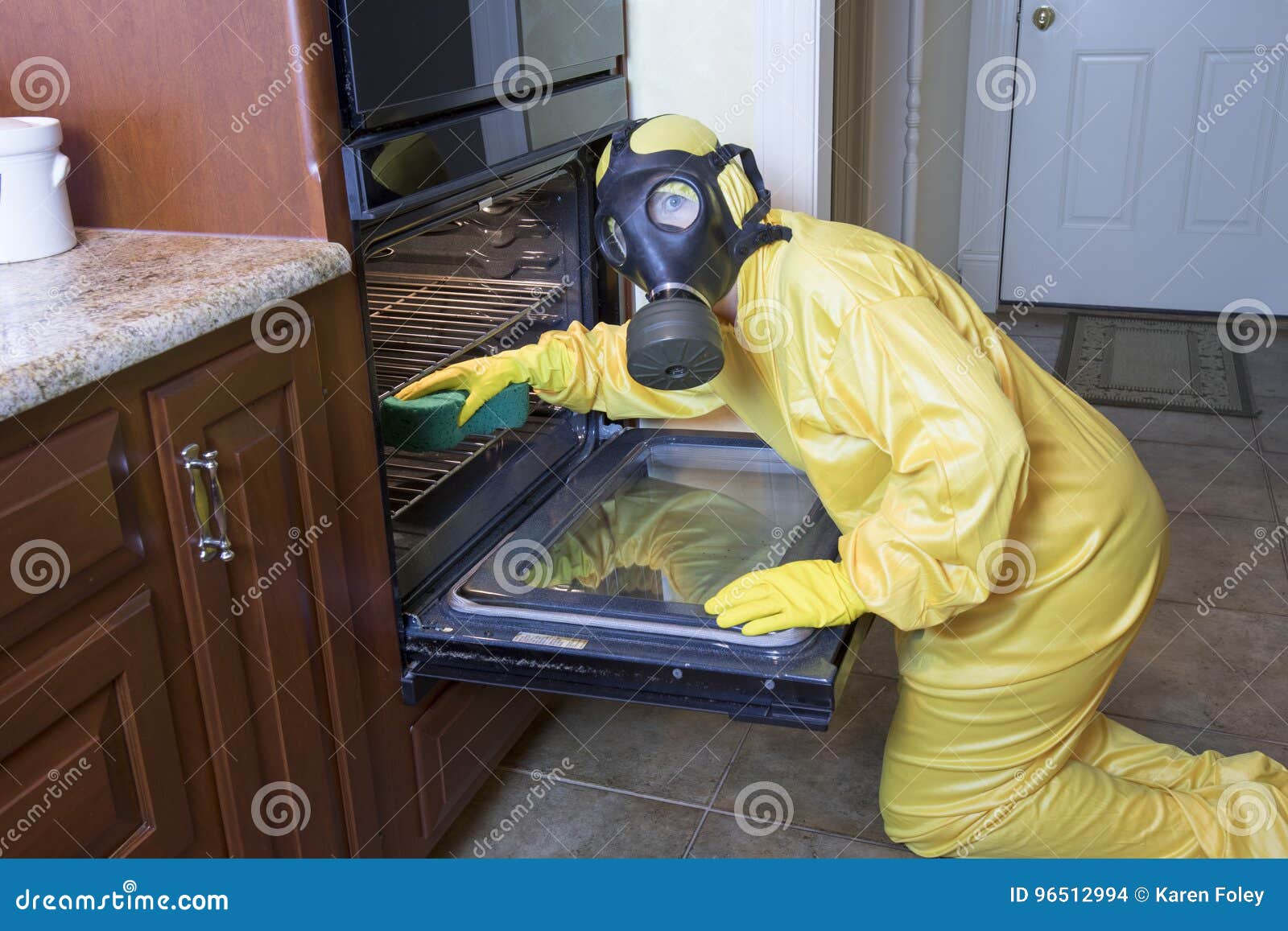 woman in haz mat suit cleaning oven