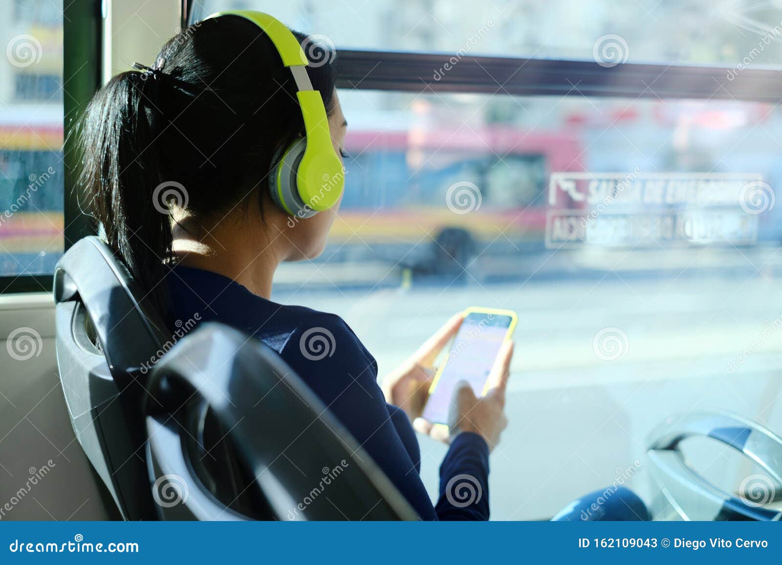 woman with headphones listening to music commuting by bus