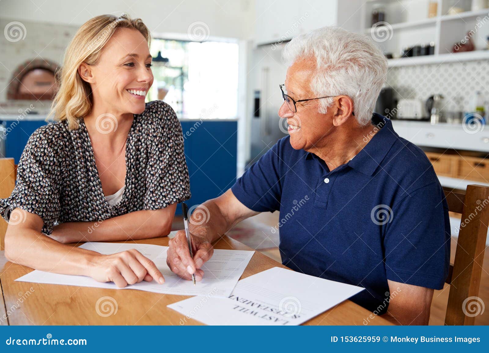 woman helping senior man to complete last will and testament at home