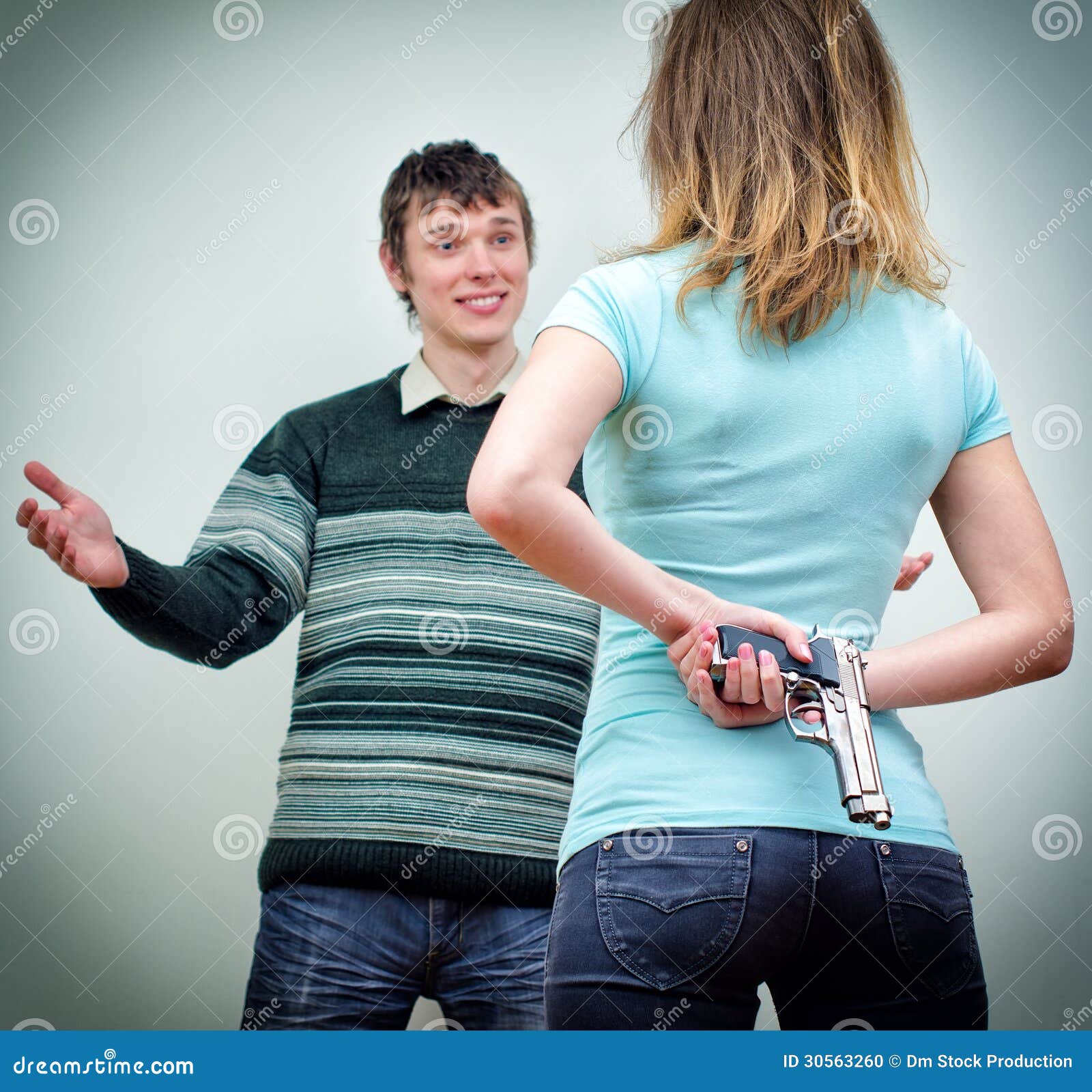 [Image: woman-hiding-gun-underhand-talking-to-man-30563260.jpg]