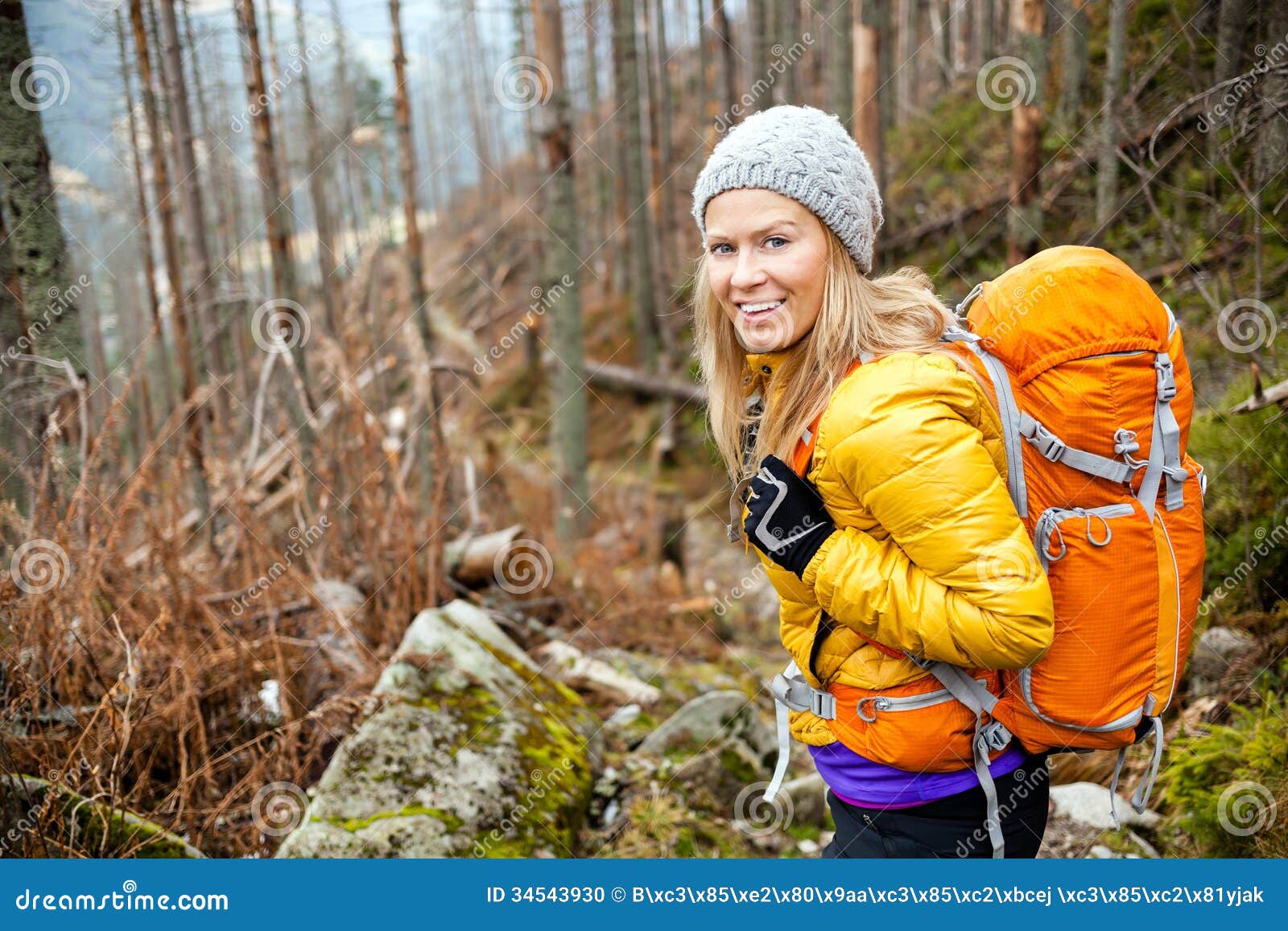 woman hiking in autumn forest trail