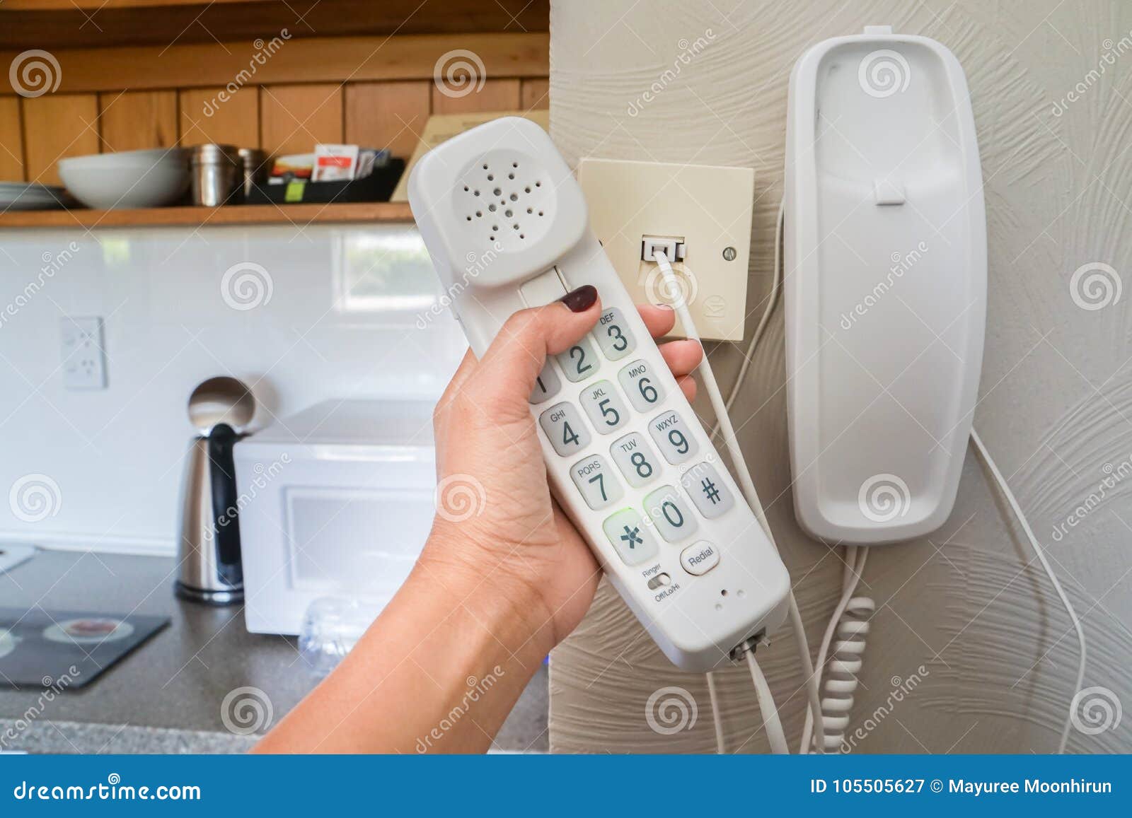 woman hold landline telephone at the house wall
