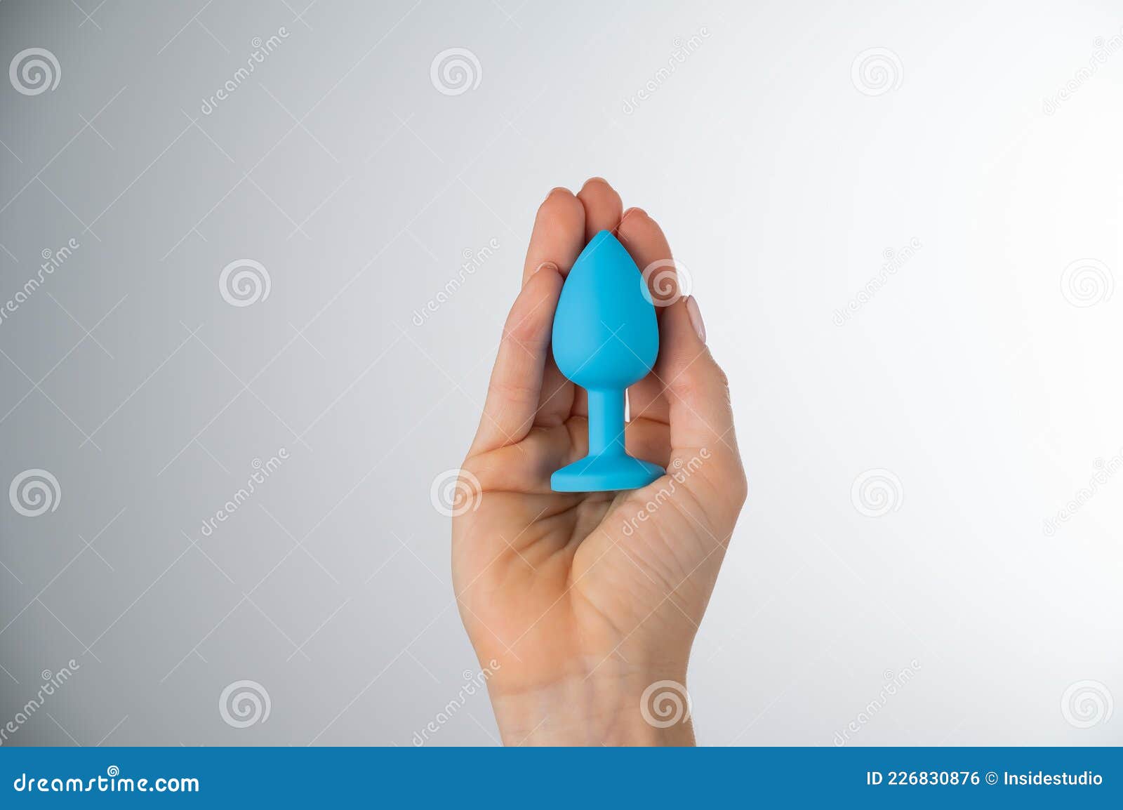Woman Holding a Blue Plug on a White Background