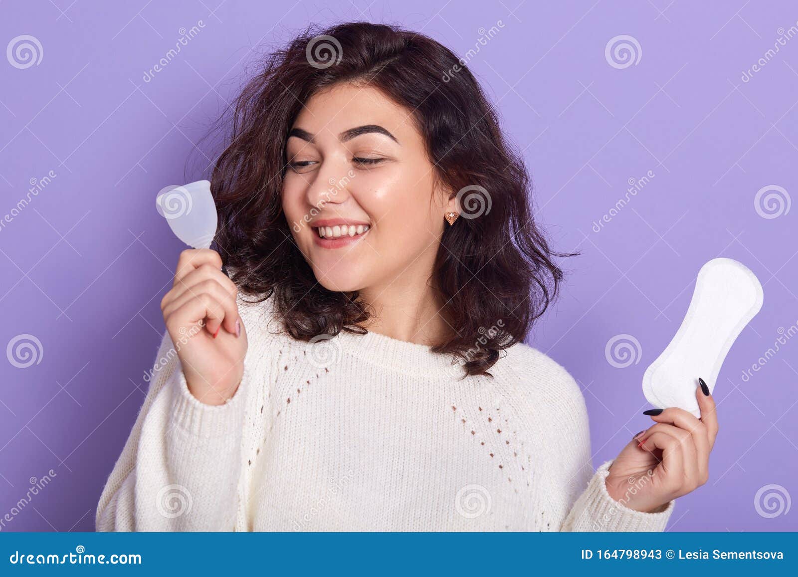 woman holding menstrual cup and sanitary pad in hands. feminine hygiene alternative product instead of tampon during her period.