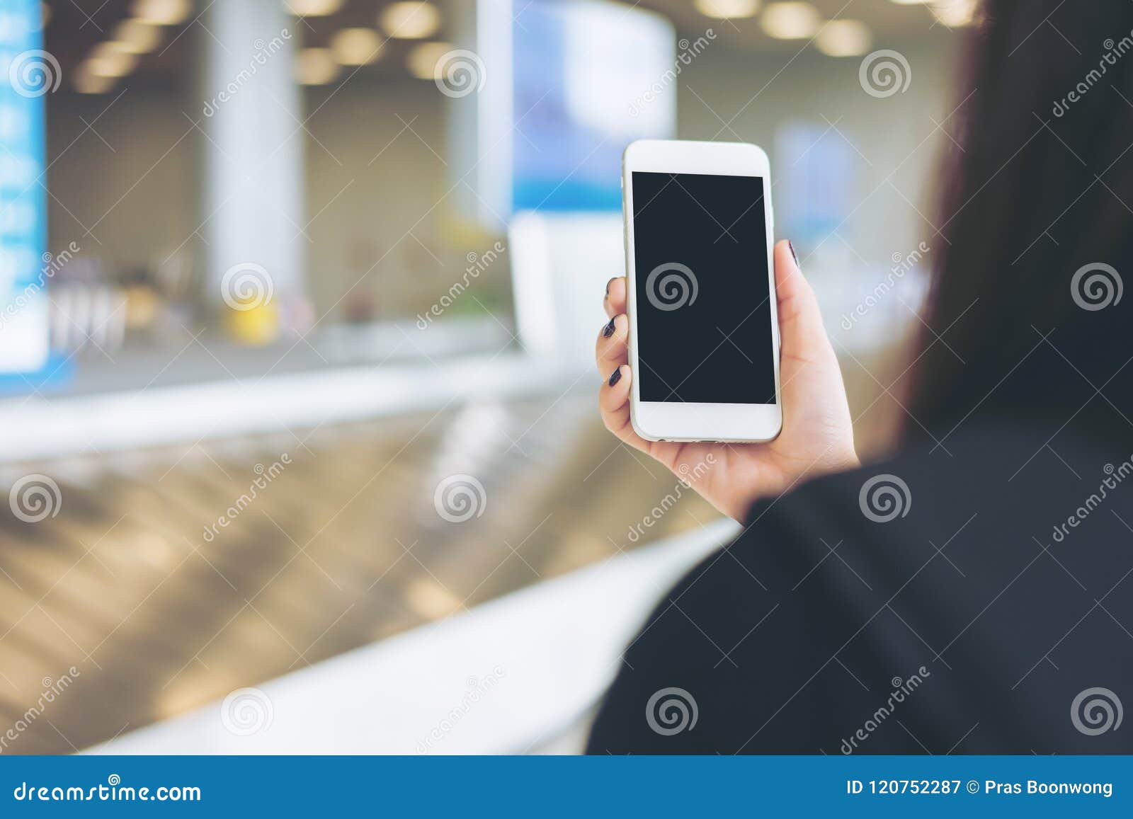 Woman Holding And Using Mobile Phone While Waiting For
