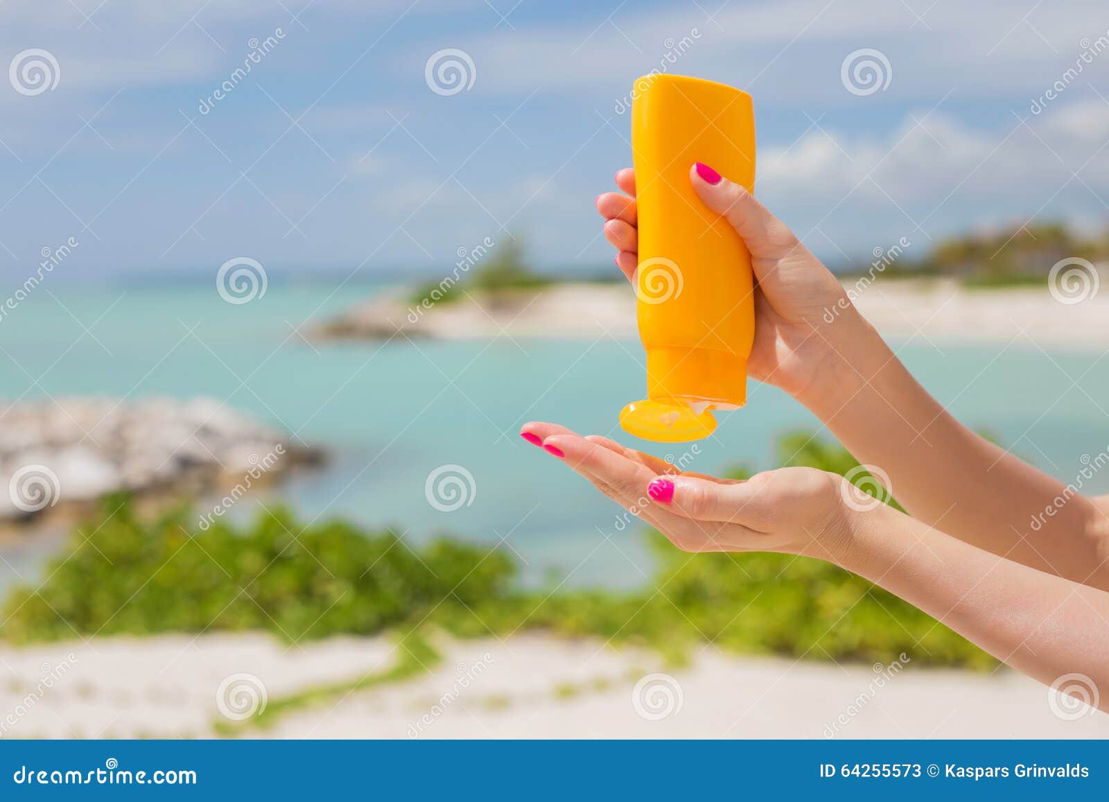 woman holding yellow sunscreen bottle in hands