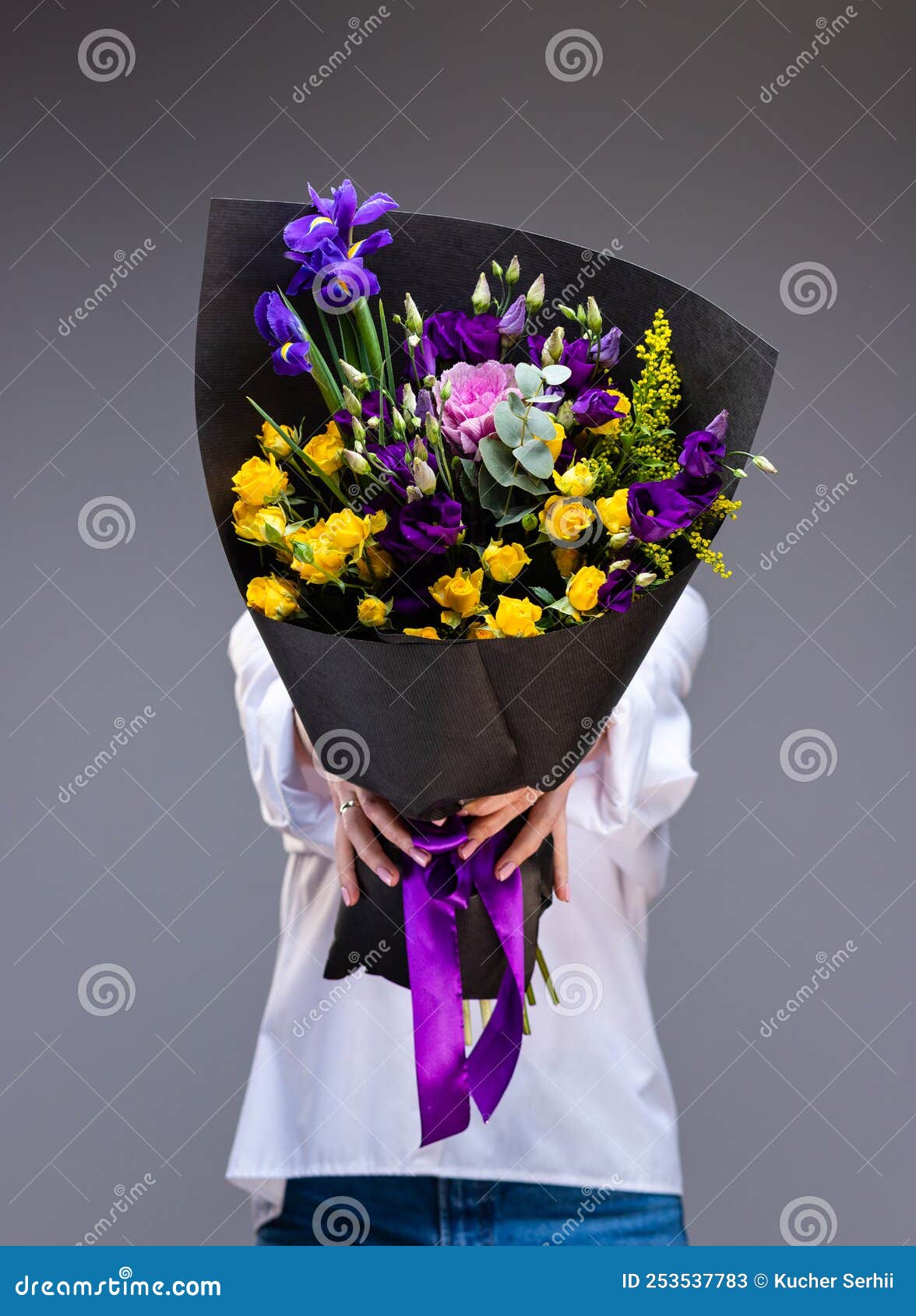 Woman Holds Out a Bouquet Wrapped in Black Paper, Covering Her