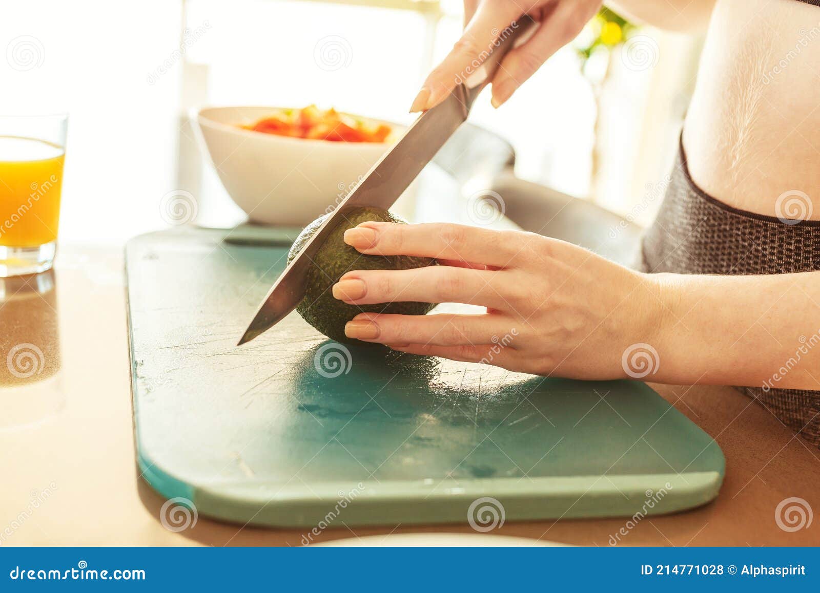 woman in the home kitchen cutting an avocado for a healthy eating