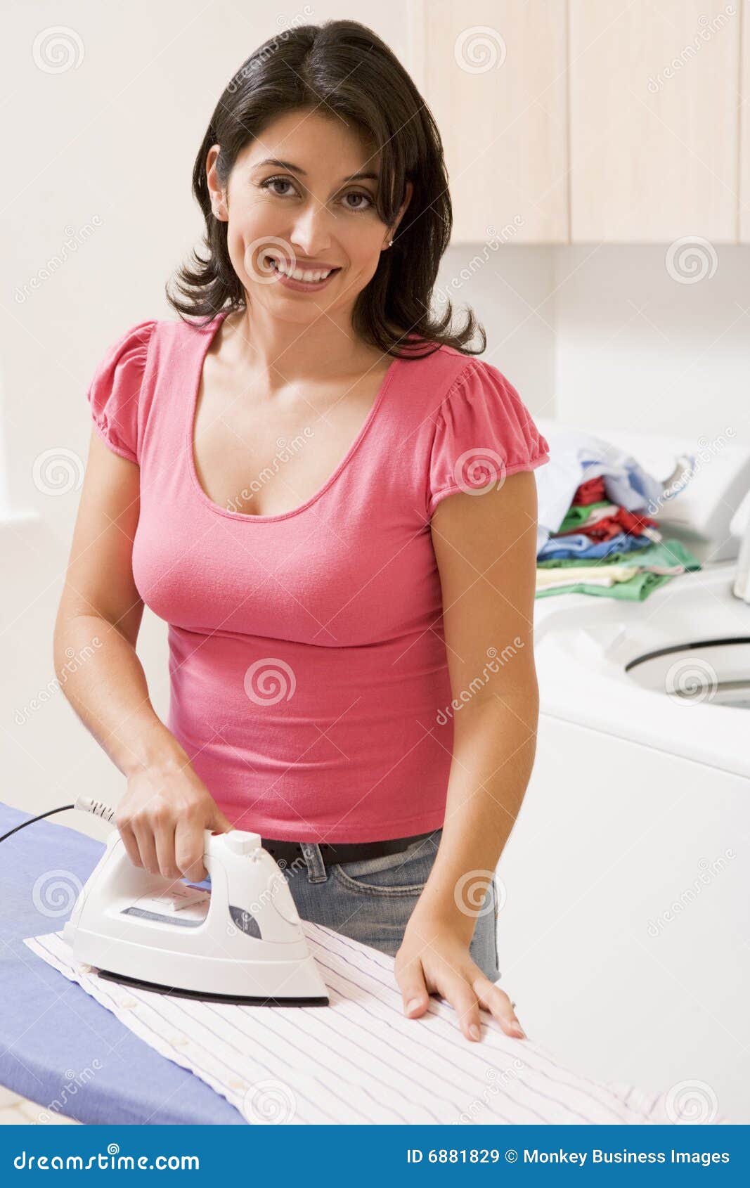 Happy Woman Ironing Cloth With Electric Iron In Kitchen, Stock